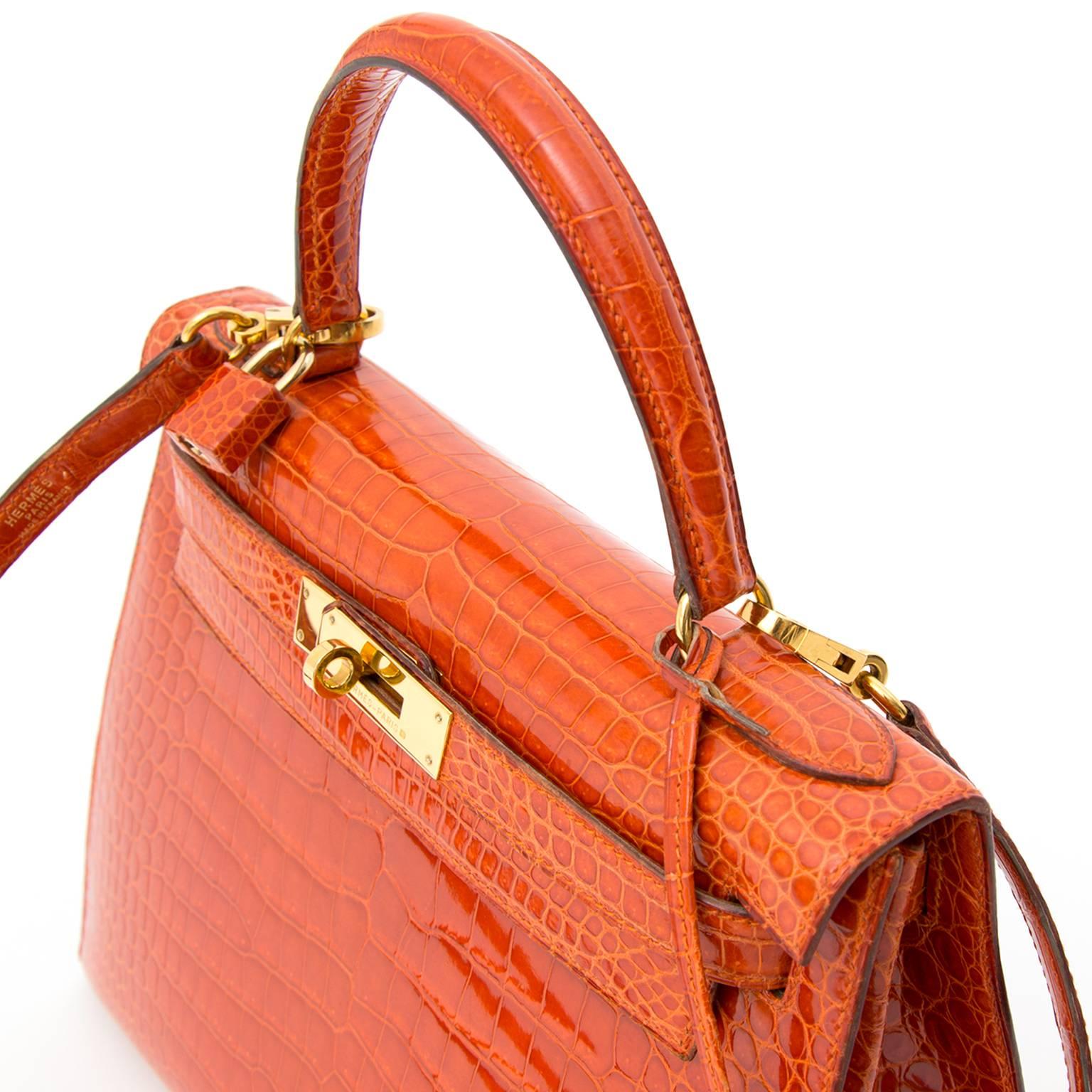 Unseen beauty! This Hermès Kelly bag in precious crocodile Porosus is dyed in one of Hermès' most stunning colors, 'Rouge Agathe'. 
It is a deep burnt orange hue that vibrates through the glossy surface of the Porosus hide and is in perfect
