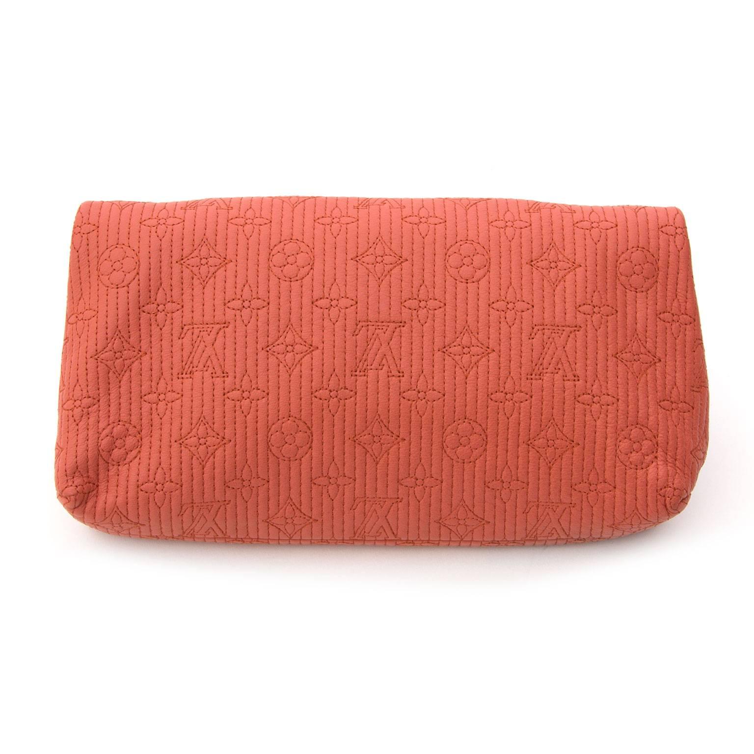 This Louis Vuitton clutch is the perfect accessory for any occasion or outfit.
This stunning clutch is crafted of Louis Vuitton monogram embossed calfskin jacquard weave fabric in matte Coral.
Golden brass metallic hardware pieces with tortoise