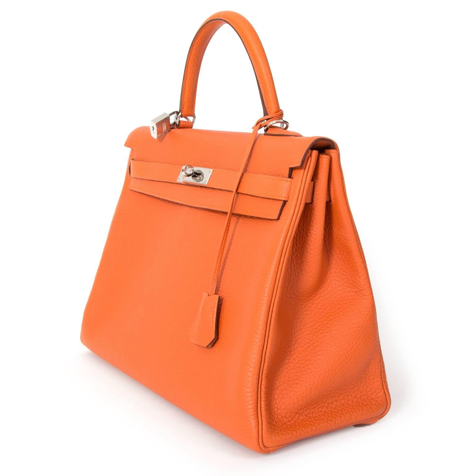 Brand new Hermes Sac Kelly Orange Retourne 35 Veau Togo in a bright orange hue. Very contemporary color for a timeless classic shape. Features silver hardware.

Comes with sleepers, lock, keys, strap and receipt (2011)

