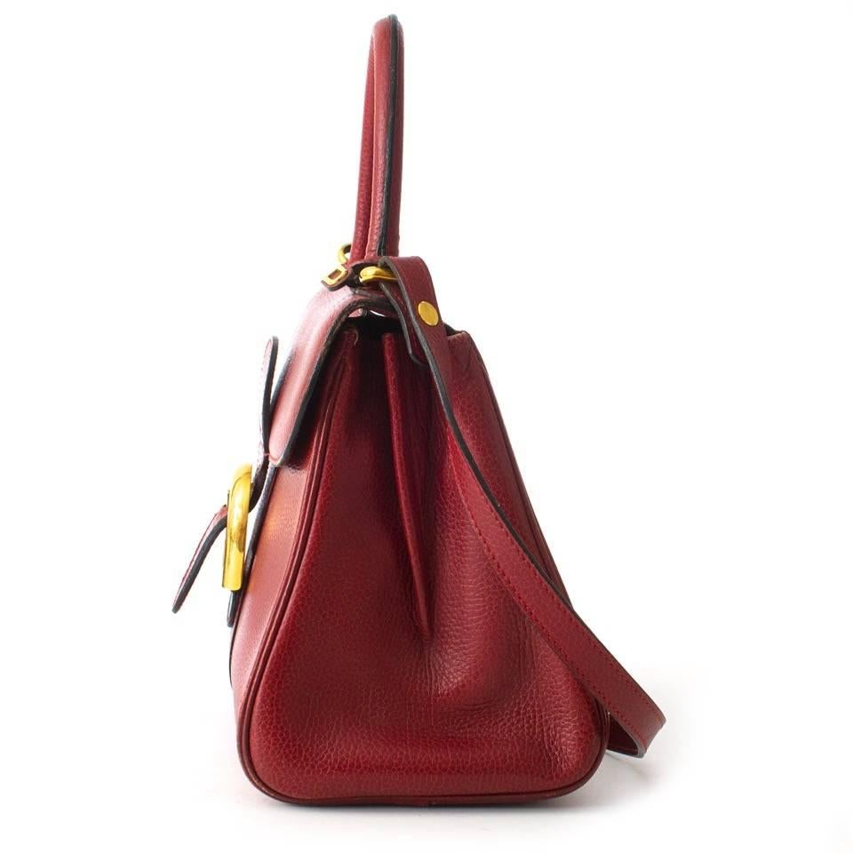 This classic item comes in a beautiful dark red and is finished with golden hardware. Bag has a top handle or can be worn with the adjustable shoulder strap. Bag comes with original dust bag, Delvaux mirror and authenticity card. 
