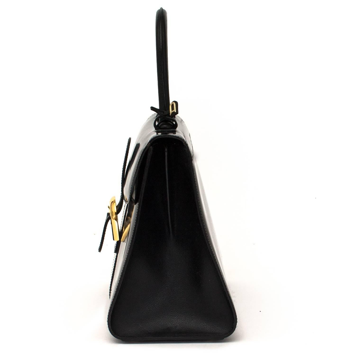 This beautiful elegant model comes in a beautiful shiny black leather. The bag features gold-toned hardware and the authentic ‘D’ hangtag. The inside contains a slip pocket with zip fastening and a little pocket for your pen. The bag comes with the