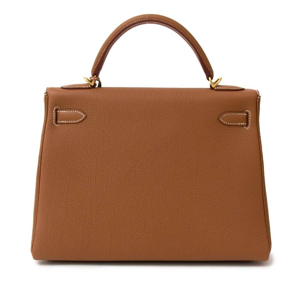 This BRAND NEW Hermès Kelly is living proof of the craftsmanship of the house of Hermès. This iconic handbag is fresh from the store. It is made from one of Hermès' most beautiful hides: the Veau Togo in a stunning Gold. The Hermès Kelly