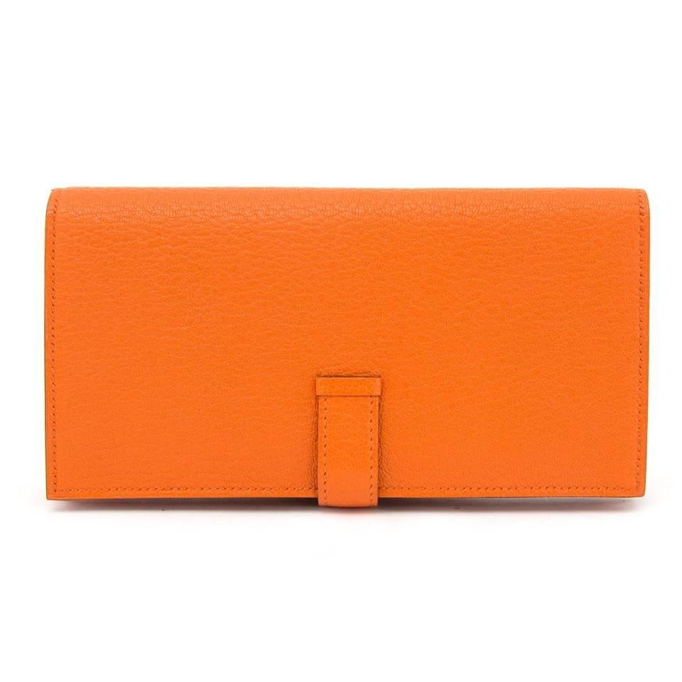 Stunning orange Hermès wallet. This wallet is handcrafted from strong goat leather, called chèvre. Dyed in this beautiful orange color. Still available in store and the plastic is still on the silver hardware.