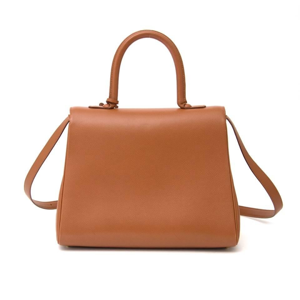 Delvaux Brillant in cognac leather with gold hardware. The Brillant bag is known for its elegance and simplicity. The bag opens with the classic gold buckle to a clean beige interior with a zip pocket, side pocket and strap to attach your keys. This