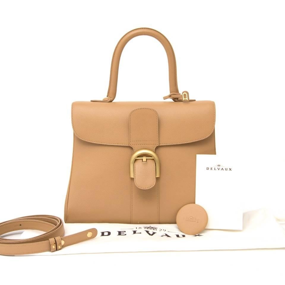 As new Delvaux Brillant MM in grained sand color leather with matte gold hardware. Top handle for comfortable use. The interior has two extra comportments of wich one with a zipper, and a keychain. Four small gold studs on the bottom to protect this