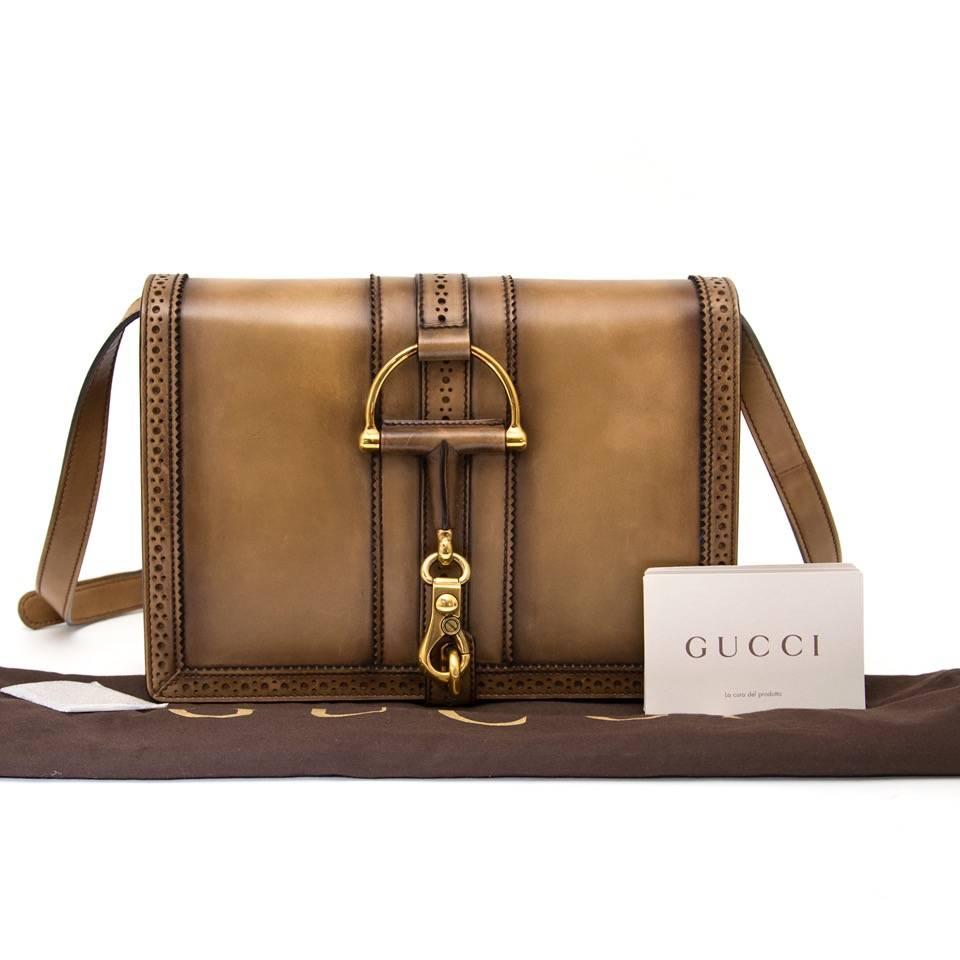 Brand new Gucci Duilio Brogue Leather Shoulder Bag in a bronzed camel hue. This limited edition handbag has been dyed by hand to achieve an exceptional look. Antique gold-toned horsebit detail and clasp on the front side of the bag. Brogue detailed