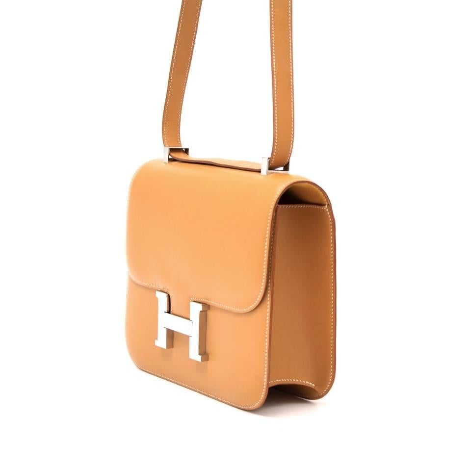 This beautiful and authentic Constance bag by Hermès in gold Barenia leather with palladium hardware. 
The bag can be worn over the shoulder with a single strap or double strap. 
The large silver tone signature Hermès H push lock closure is