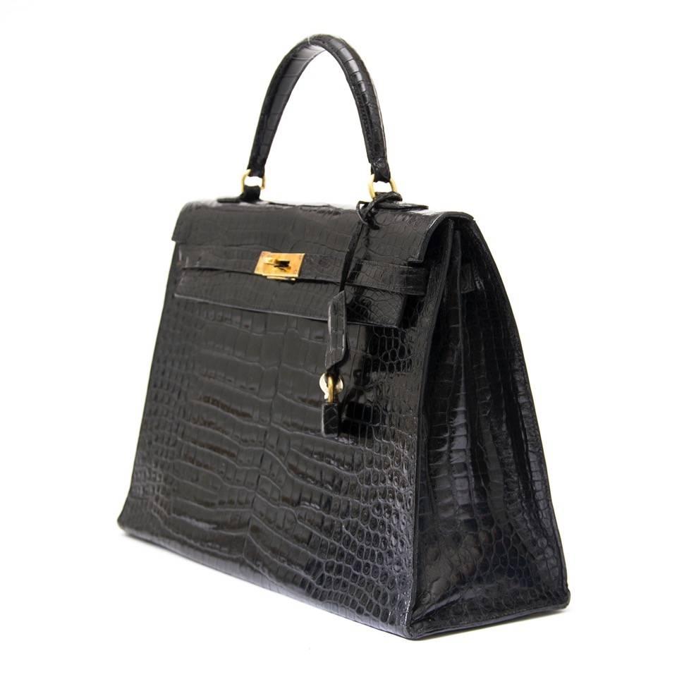 This beautiful Kelly comes in a black crocodile leather combined with gold-toned hardware. The interior of the bag contains a zip pocket and two slip pockets. Item comes with keyholder and padlock. 
Blindstamp T shows the bag was made in 1964.