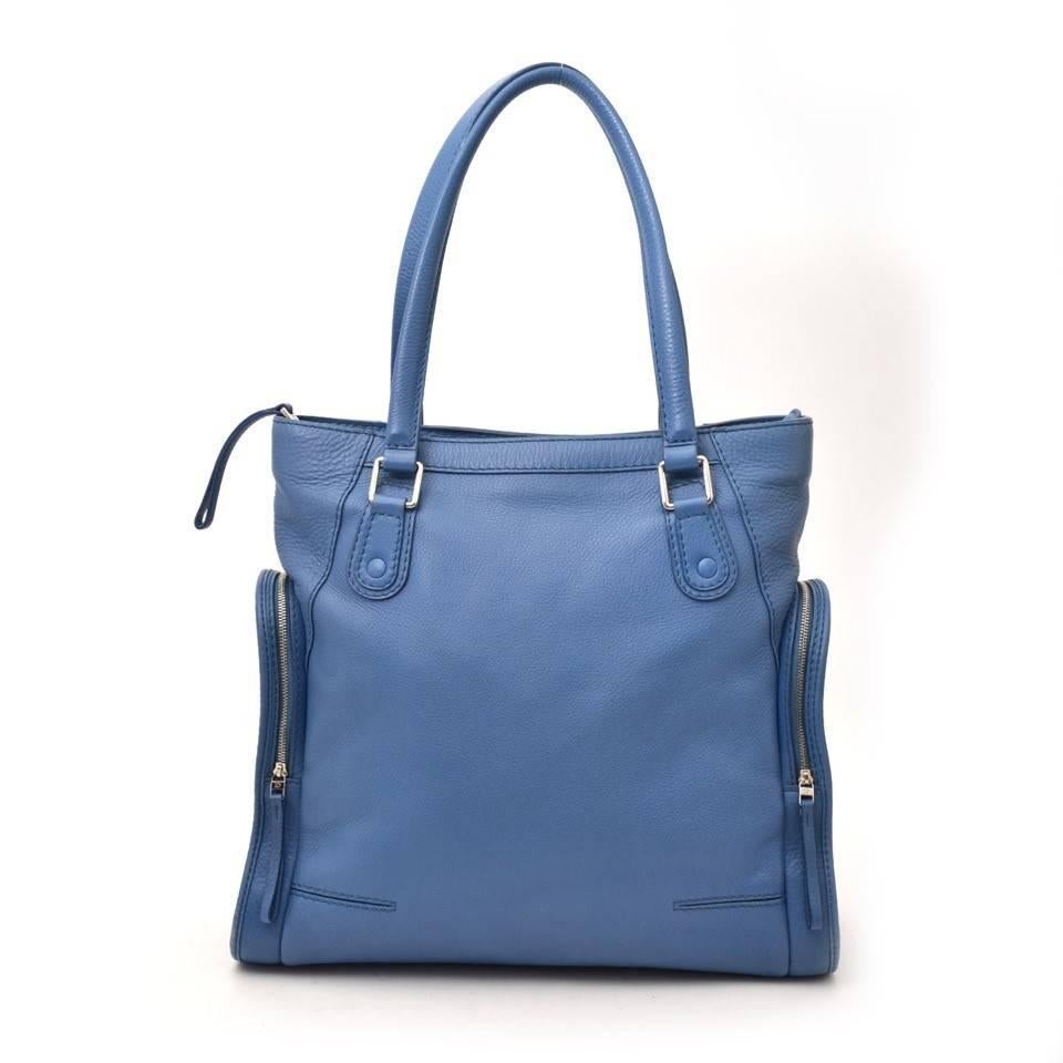 Delvaux Blue Tote Bag 
Tote bag by the Belgian brand Delvaux in blue soft leather. 
Smaller oval shaped zipper compartments on the sides. 
Simple but sofisticated bag with silver hardware. 
Perfect to keep all your daily essentials and papers.
Comes