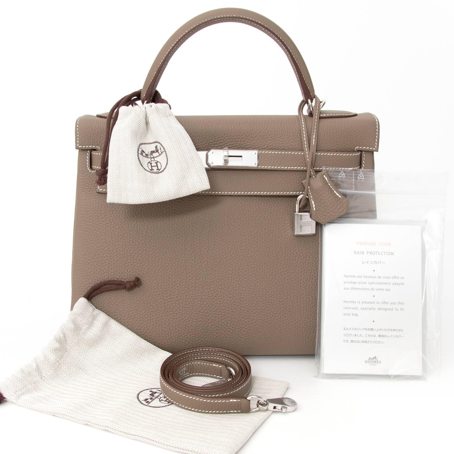 This Hermes Kelly in timeless etoupe is a real statement piece. This Kelly bag is made of the Popular Togo leather. The Kelly bag is accented with palladium hardware and features a single top handle, turn-lock closure, and four protective base