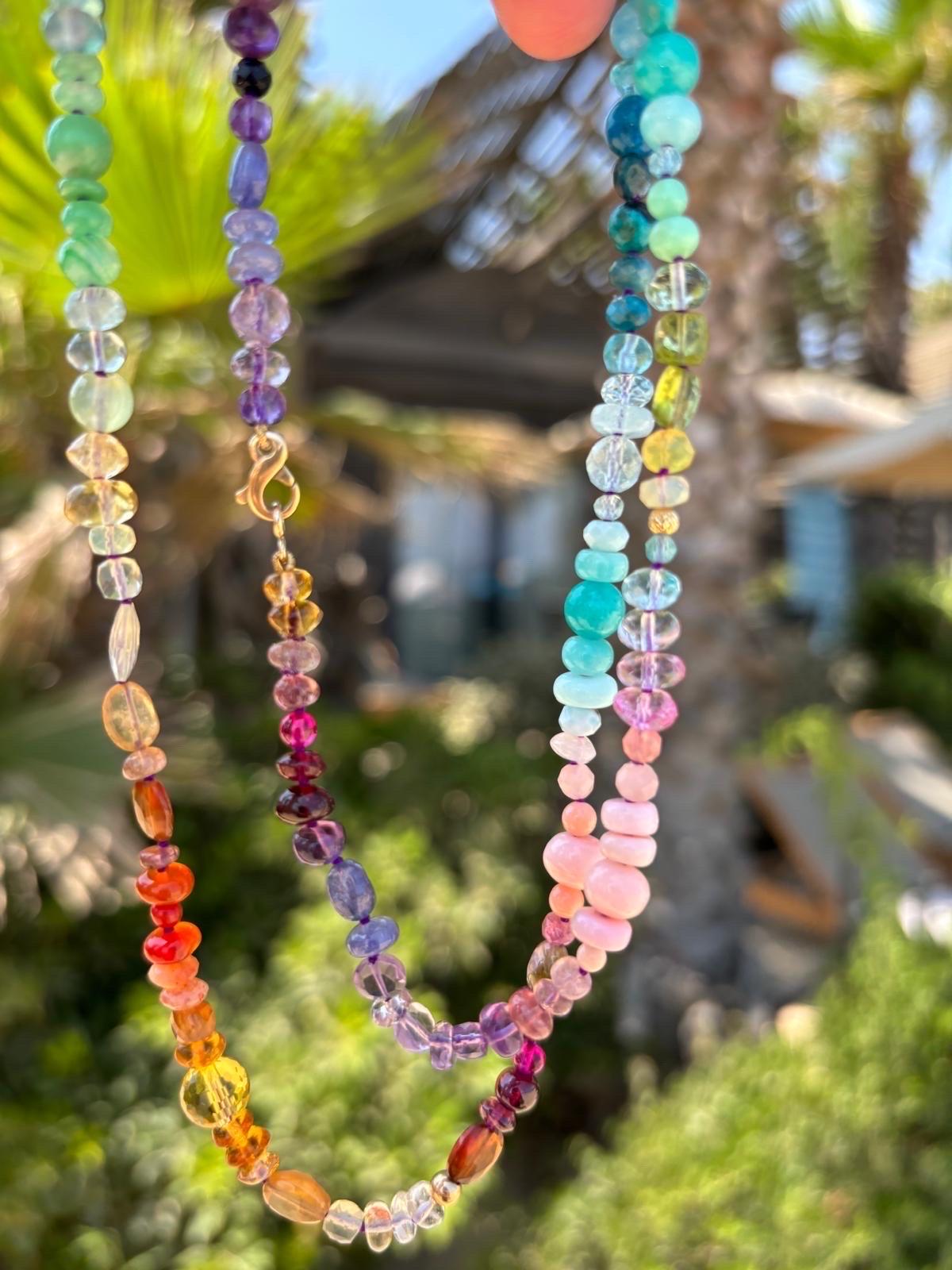 Umarmen Sie sich mit funkelnden Edelsteinen, die die Farben des Regenbogens einfangen! Die facettierten Formen der Steine unterstreichen die Schönheit dieser Halskette. Die Edelsteine haben einen facettierten Schliff und verschiedene Formen, die das