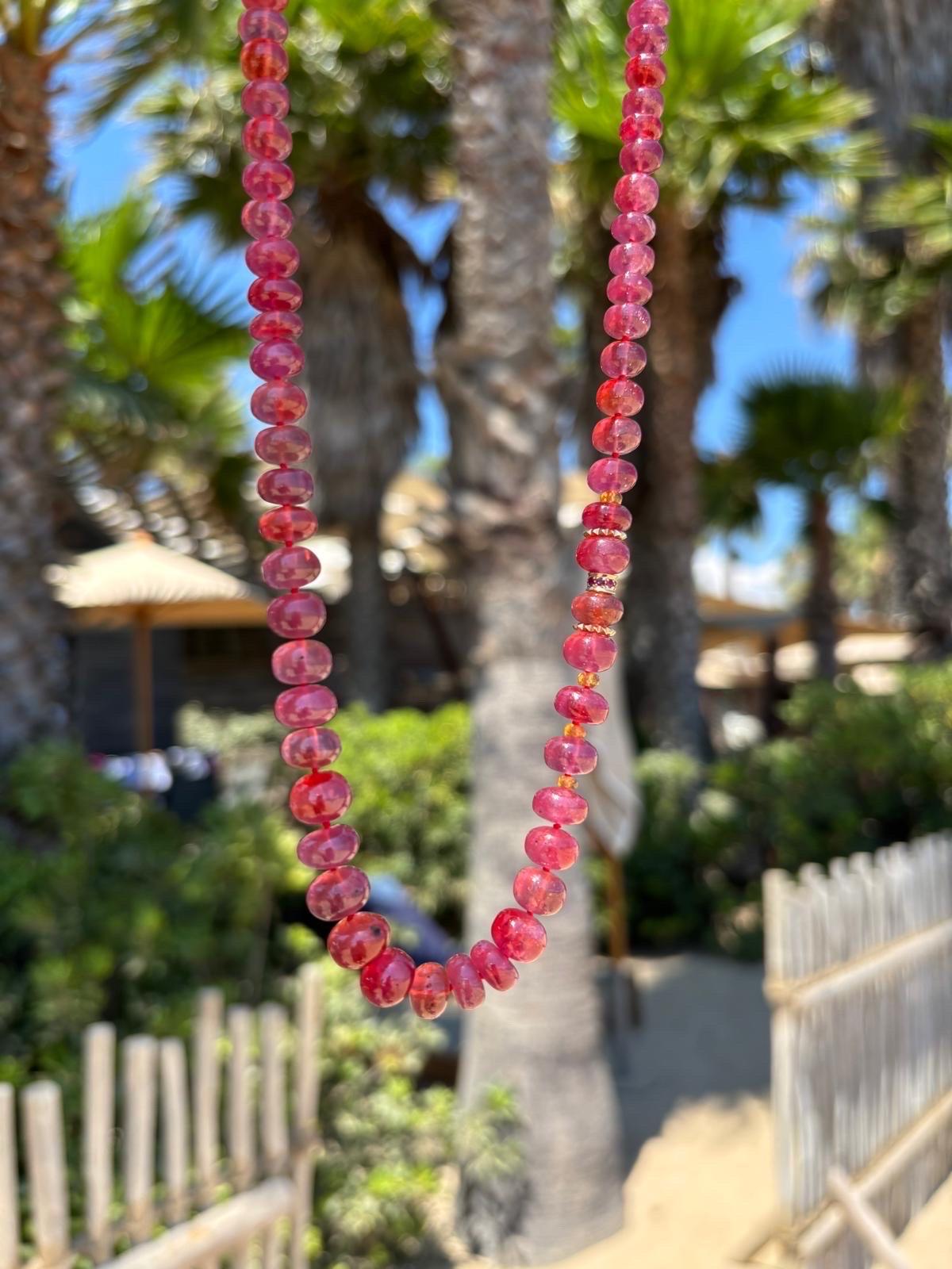 Add a mesmerizing touch to any outfit with this pure deep redish pink ruby beaded necklace in 14K yellow gold. 
This stunning necklace is made with high carat 14K yellow gold hand carved sparkling beads, orange mandarin garnet and features a