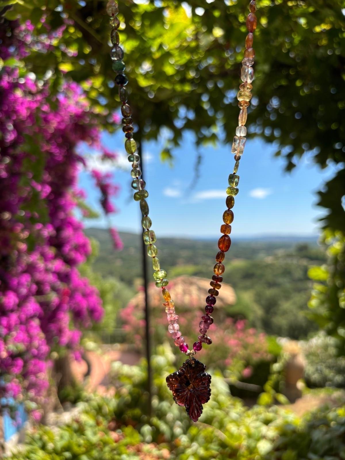 Add a mesmerizing touch to any outfit with this tourmaline beaded necklace in 14K solid yellow gold. This handmade necklace is made with gold beads, tourmaline charms, sparkling gemstones and large hand carved flower pendant. 

The necklace is 19.5