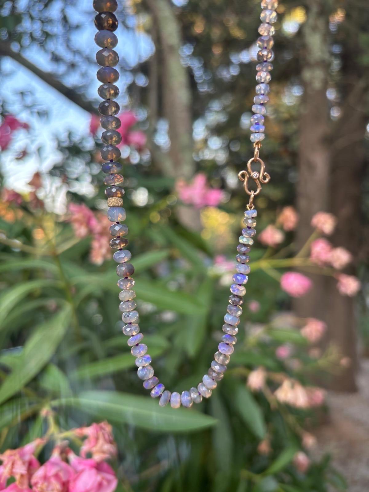 A very rare dark Australian lightning ridge opal necklace, methiciously hand knotted, finished with an 18K gold diamond clasp and beads. The necklace has recently been restrung. All stones are hand carved and catch the light in dazzling ways. The