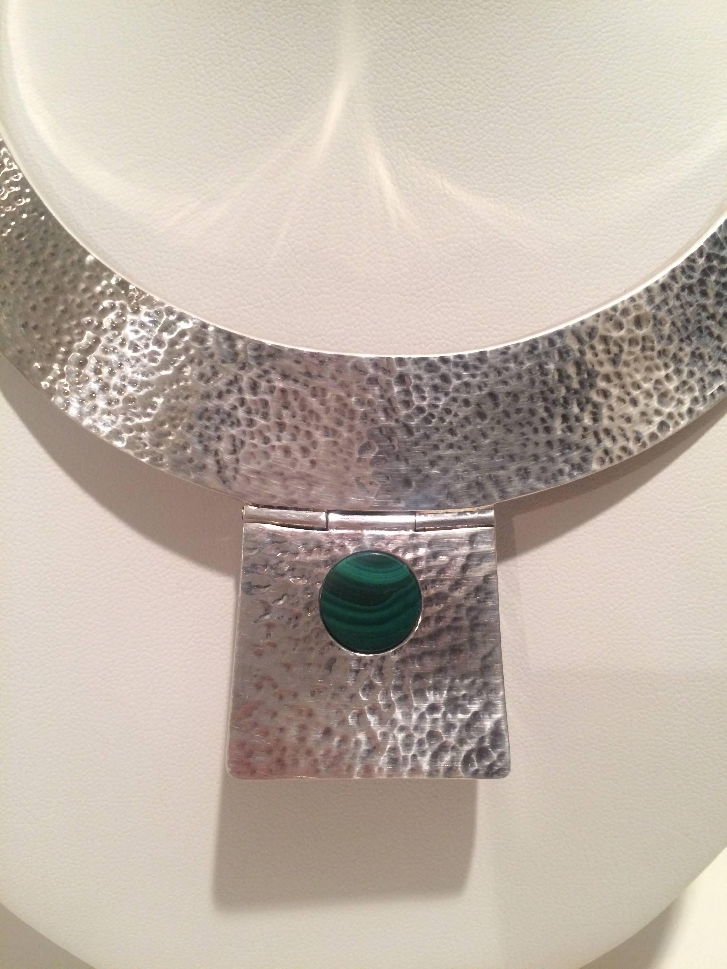 From the Estate of Charlton Heston and worn by his wife, Lydia, a hammered Sterling Silver necklace / collar with Malachite detail on hinged extension. 

See our companion Malachite ring from the Charlton Heston Estate on our page.
