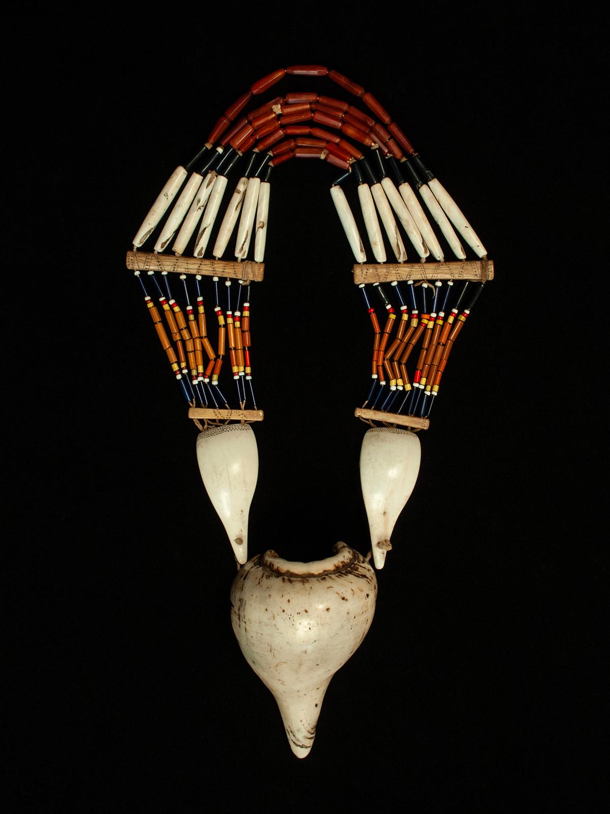 Collana della fine del XIX-inizio del XX secolo, popolo Angami, Nagaland, India
Conchiglia, corniola, osso, perle di vetro

Questa sostanziosa collana del popolo Agami è composta da sette file di corniole, vetro e conchiglie lunghe che sono
