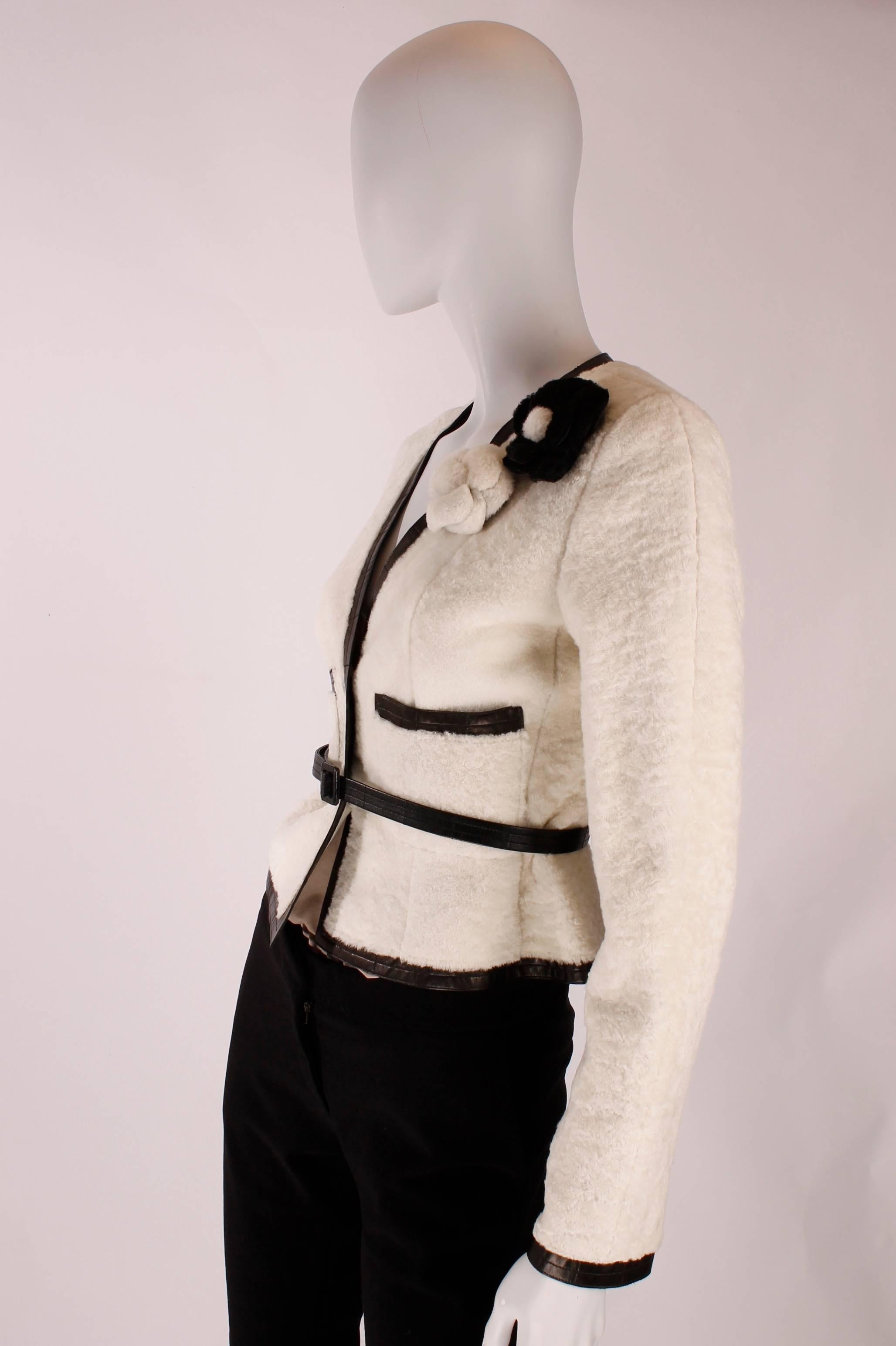 Really stunning Chanel jacket in lambskin leather, used 'inside-out'.

The soft and hairy side is on the outside, the smooth leather side on the interior. Trimmed with black leather on the hems, sleeves and pockets. Two white leather buttons with