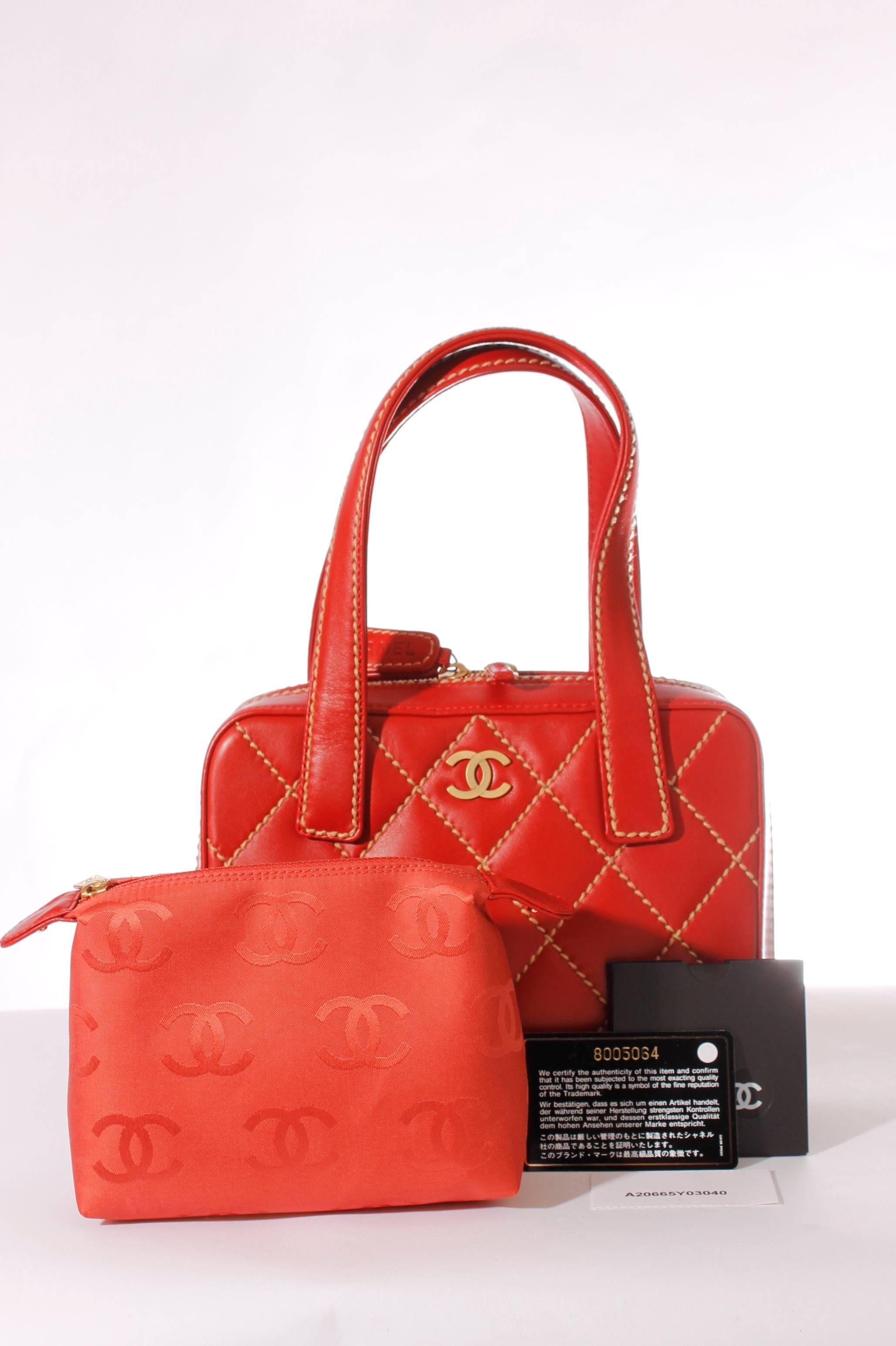 This is the Chanel Wild Stitch Quilted Zip Tote Bag in beautifully red calfskin leather.

On top a long golden 2-way zipper, one of the runners has a little strap of leather, the other has a large label. The word CHANEL is stamped on both sides of