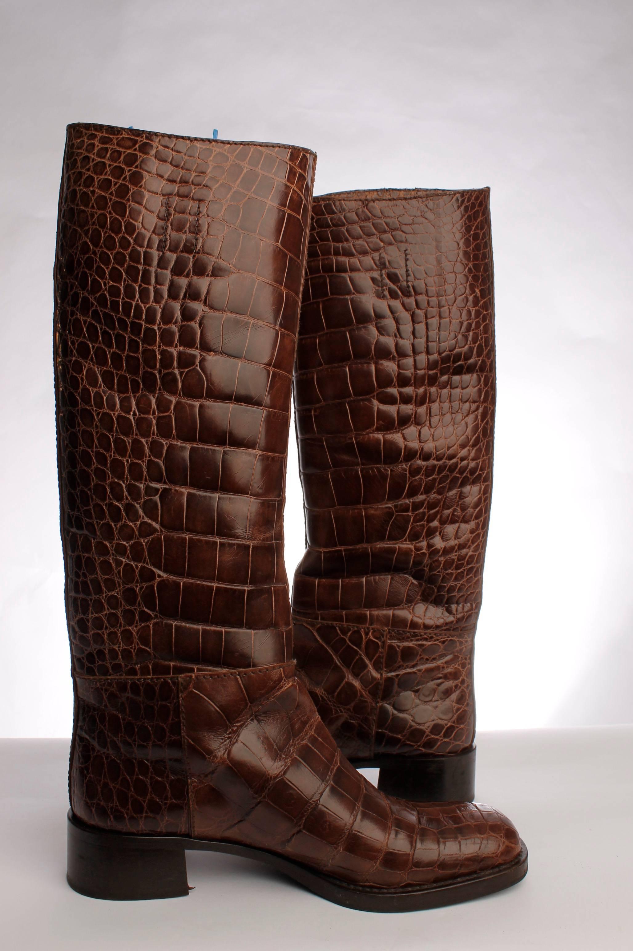 

Knee length Prada boots in dark brown crocodile leather, a slightly square toe and a cuban heel of 4 centimeters high. Beautiful, stylish and the trend for coming winter!

The shaft measures about 39 centimeters and has no zipper or elastic.