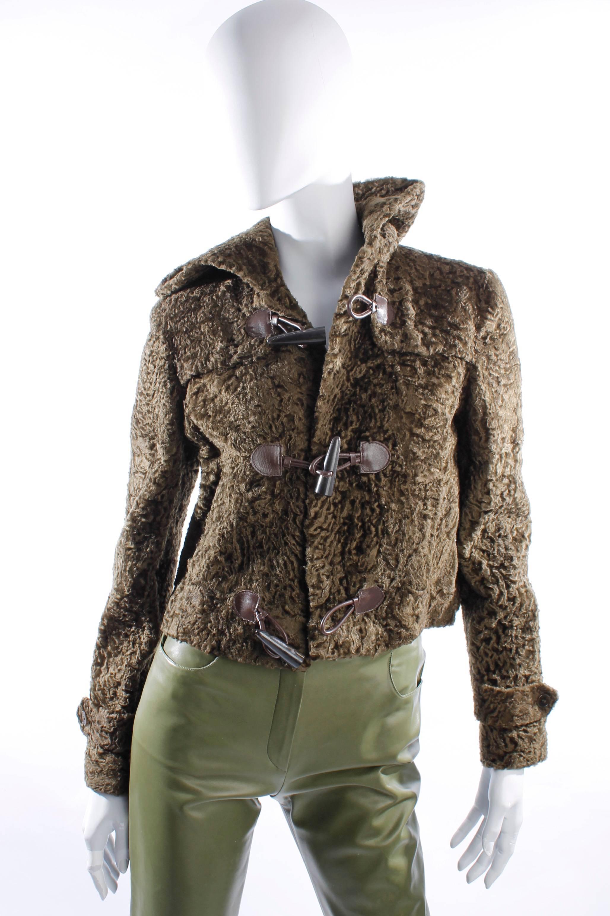 Cropped fur coat by Ralph Lauren in olive green with a hoodie and toggle fastening.

This jacket is lined with shiny green fabric. Two slit pockets above the hip and decoration-straps at the end of the sleeves.

Fully made of lambs fur.

Made