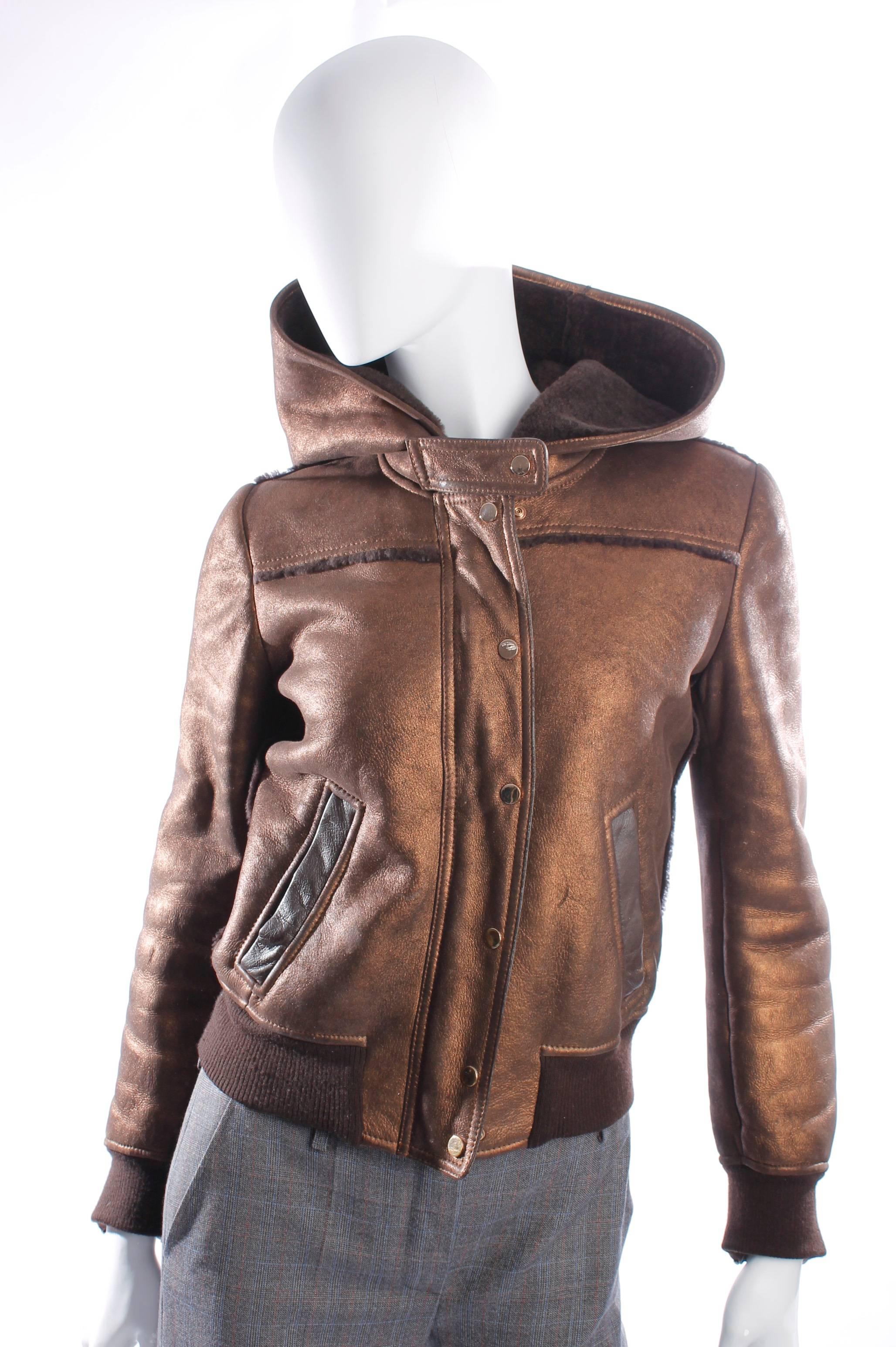 Beautiful Dolce Gabbana & lammy in dark brown leather with a pink gold finish.

Very dark brown and soft sheep fur on the inside, visible at the large hood. At the front close this jacket with a pink gold zipper and 7 pink gold printers.

Two
