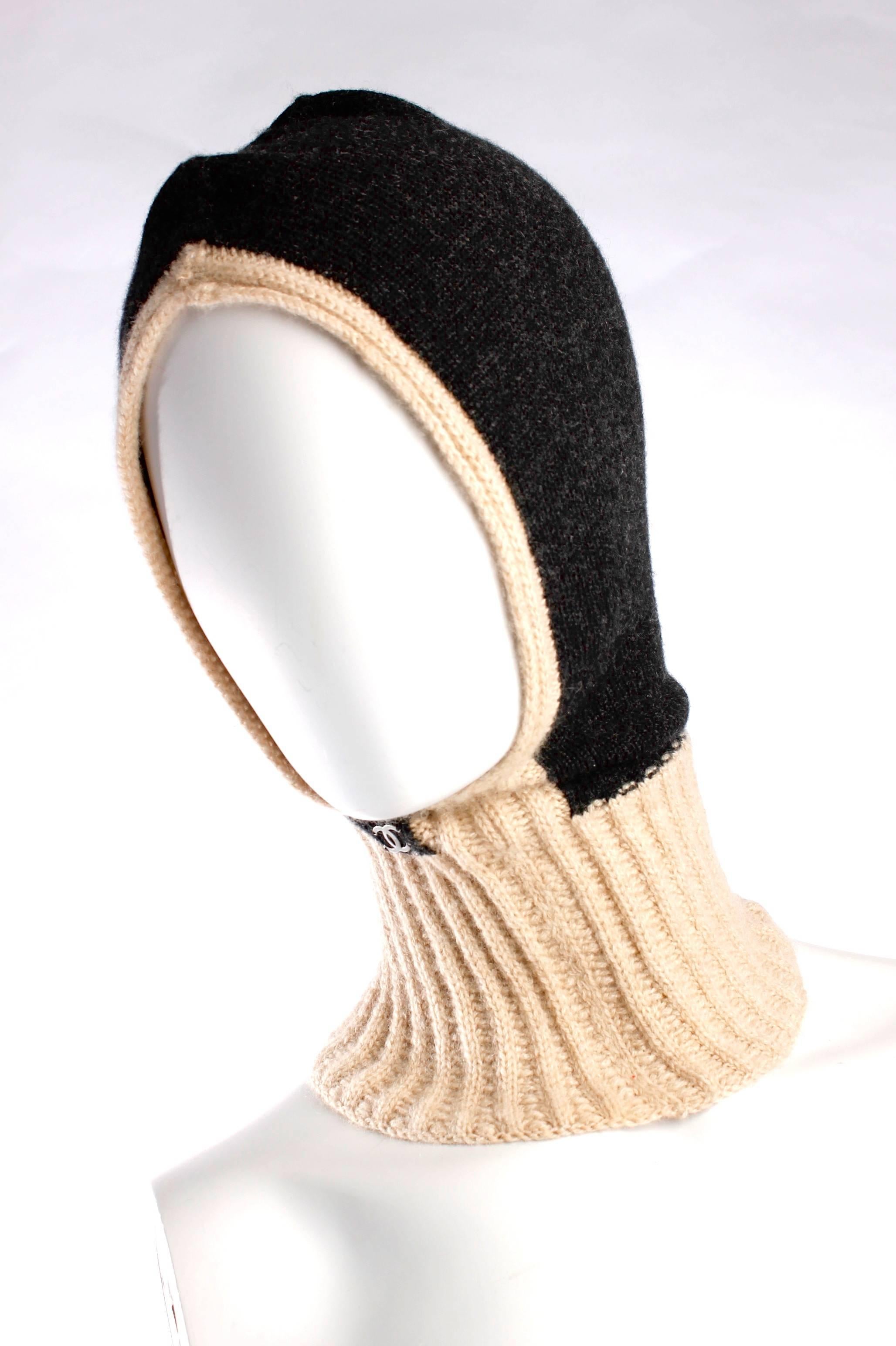 Fancy and warm! Chanel cashmere hat in dark grey and beige, this is also called a balaclava.

The hat is in dark grey, the collar and trimming in beige. On the right side a litlle metal CC-logo in grey.

New and never been worn, comes with it