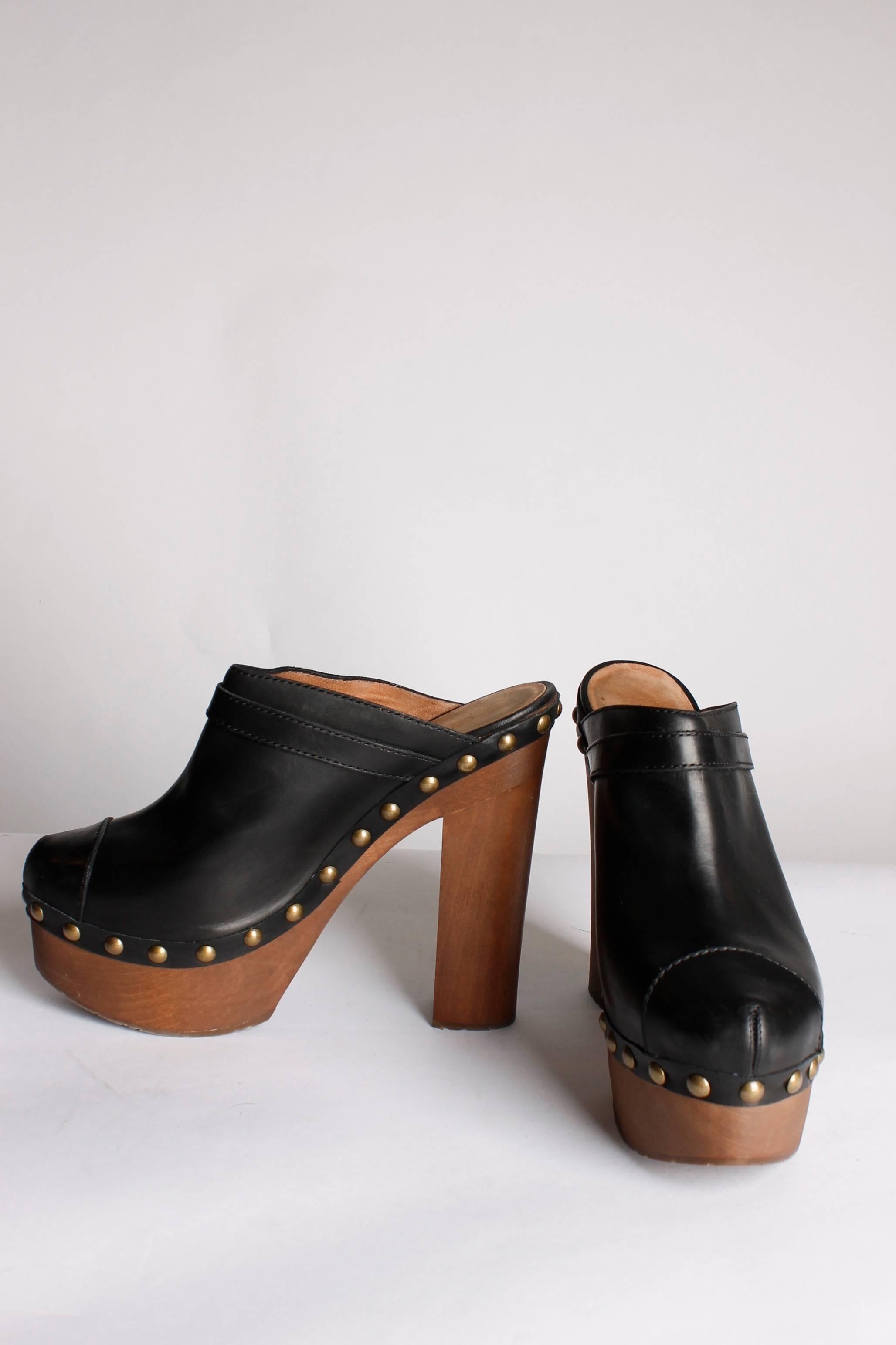 High heeled clogs by Chanel! This pair rocks!

Made of black leather, copper studs and a skyhigh heel of 16 centimeters. The platform measures 6 centimeters. Only been worn once, in perfect condition. 

A double toe piece and a little belt on