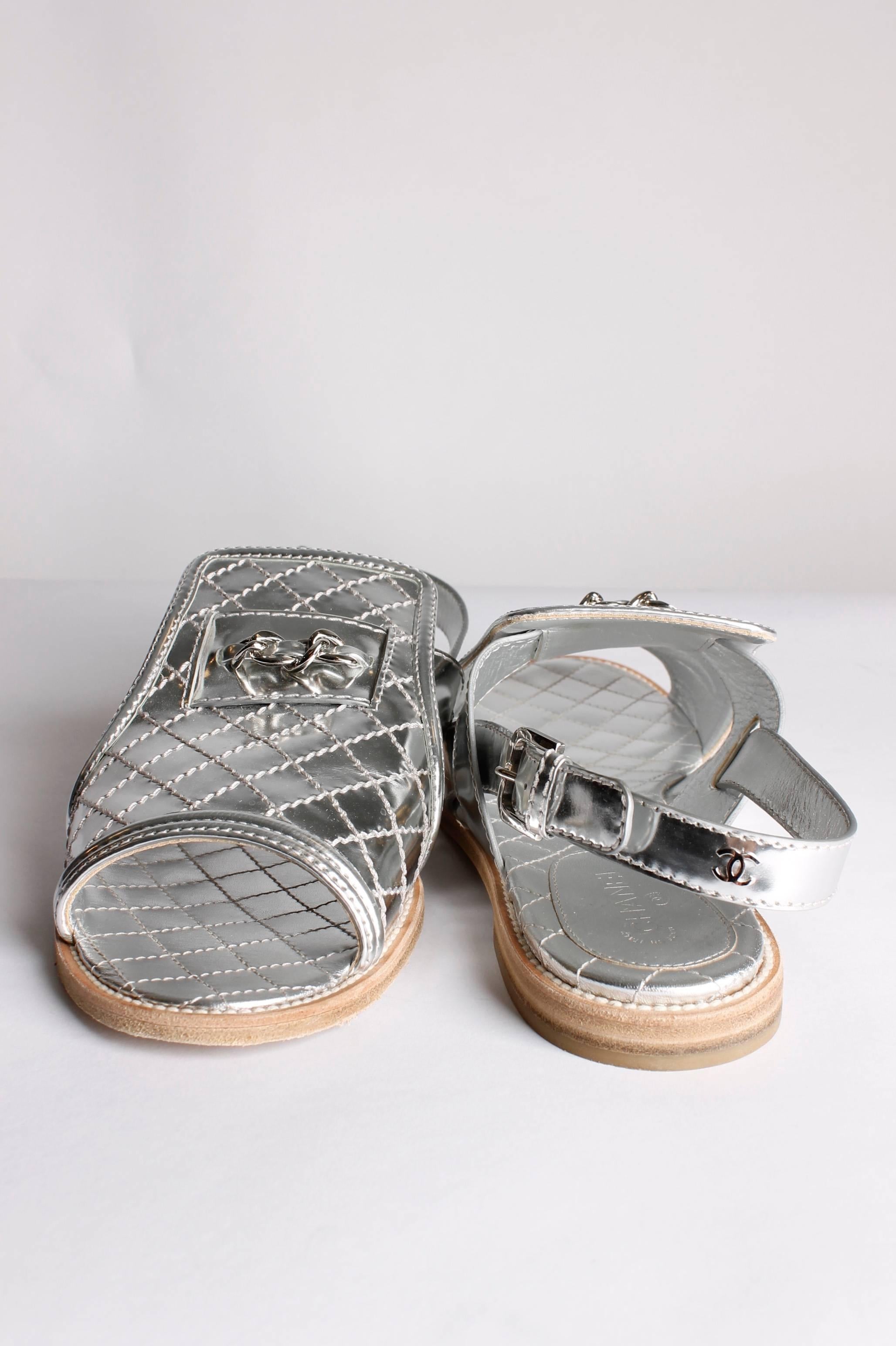 This pair shines right at you, fantastic Chanel sandals in shiny silver.

Fully quilted silver leather, a peep-toe and a heel-strap. Heel measures 1,5 centimeters, leather sole. On the front a little piece of a silver chain is attached.

Barely