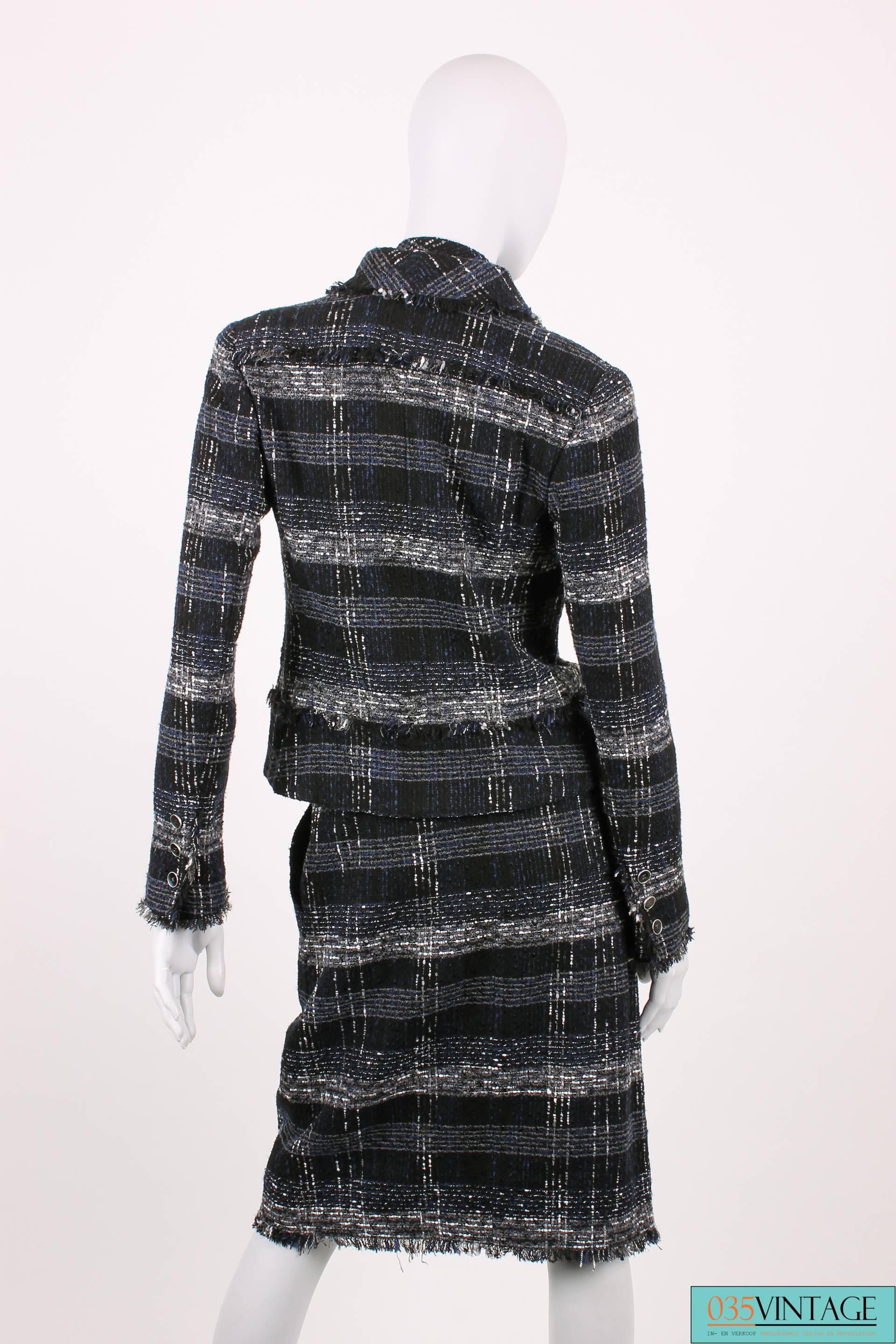 Chanel suit from the Ready To Wear Runway Spring Collection of 2005, breathtaking!

The dark blue, black, grey and white checkered jacket has a collar and a five button closure at the front. The buttons are black and silver, an interlocking