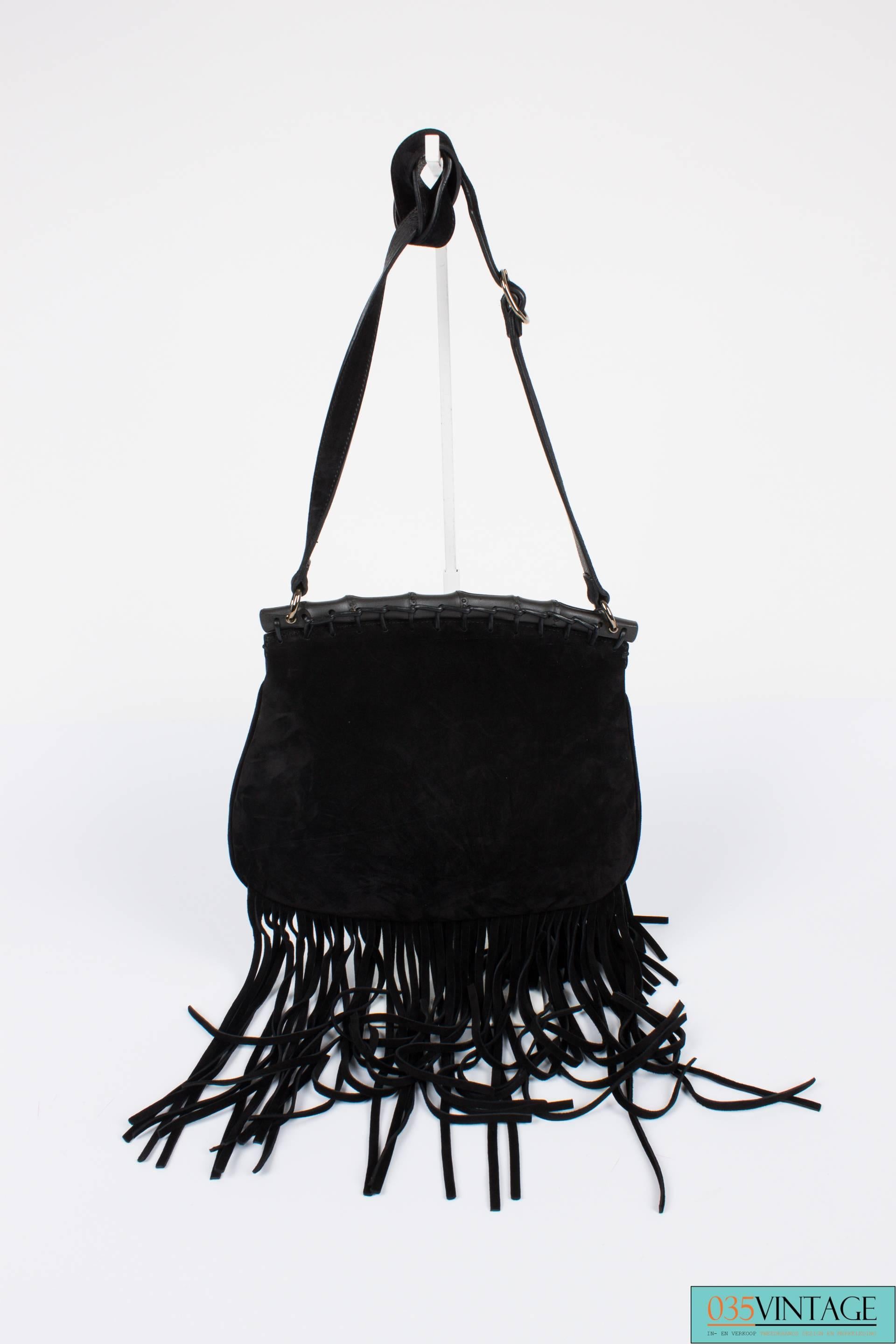 his bag is a statement piece! It is the Gucci Nouveau Fringe Suede Shoulder Bag.

Made of tarry black suede with matte black bamboo and silver hardware. A long adjustable shoulder strap. At the front a large flap, but the bag has not a real