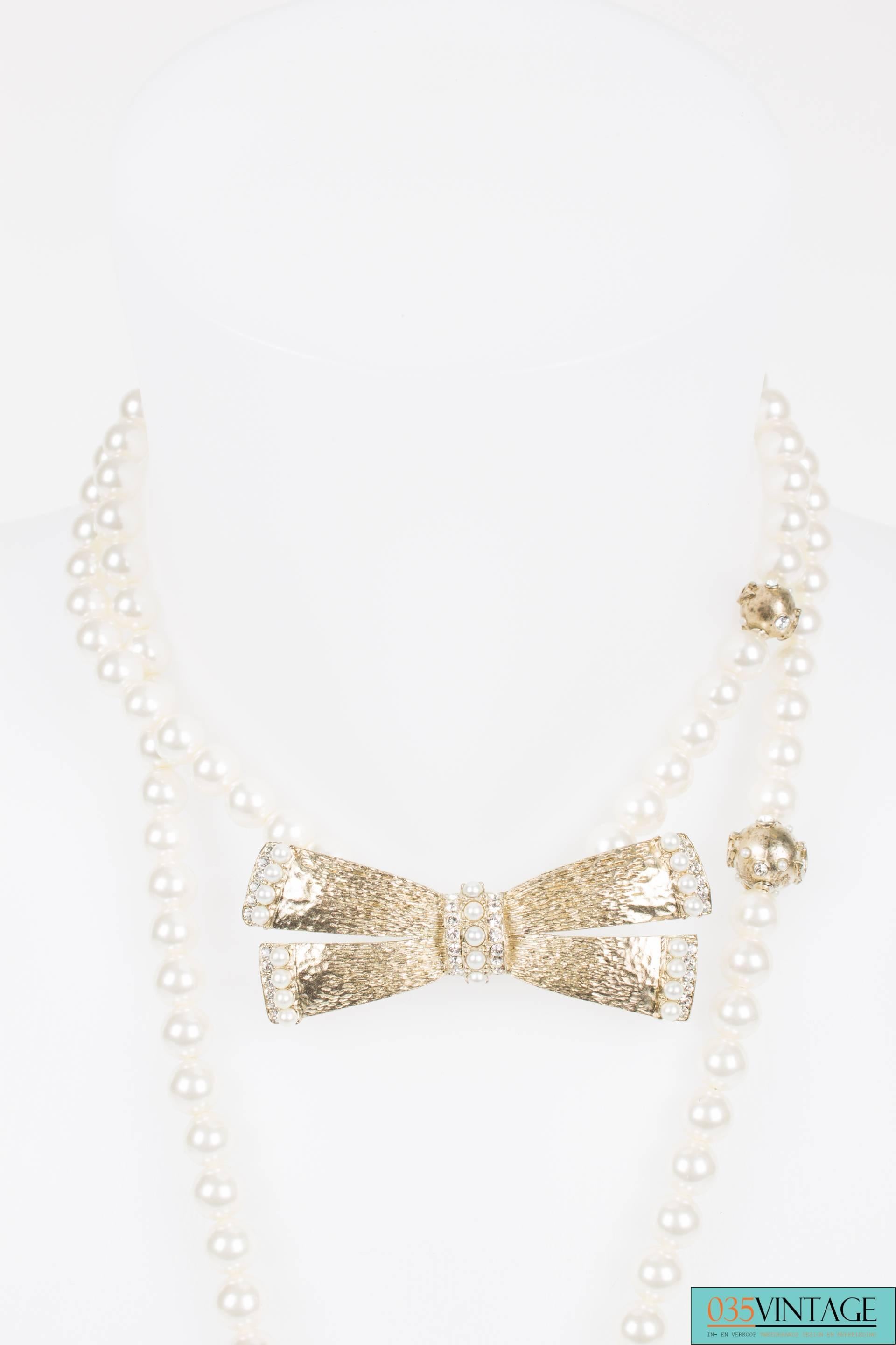 This beautiful Chanel necklace measures as much as 130 centimeters and can be worn in different ways.

The bow can be placed directly around the neck, so the necklace has a longer and a shorter part.  Or you can just wear it 'single', simply place
