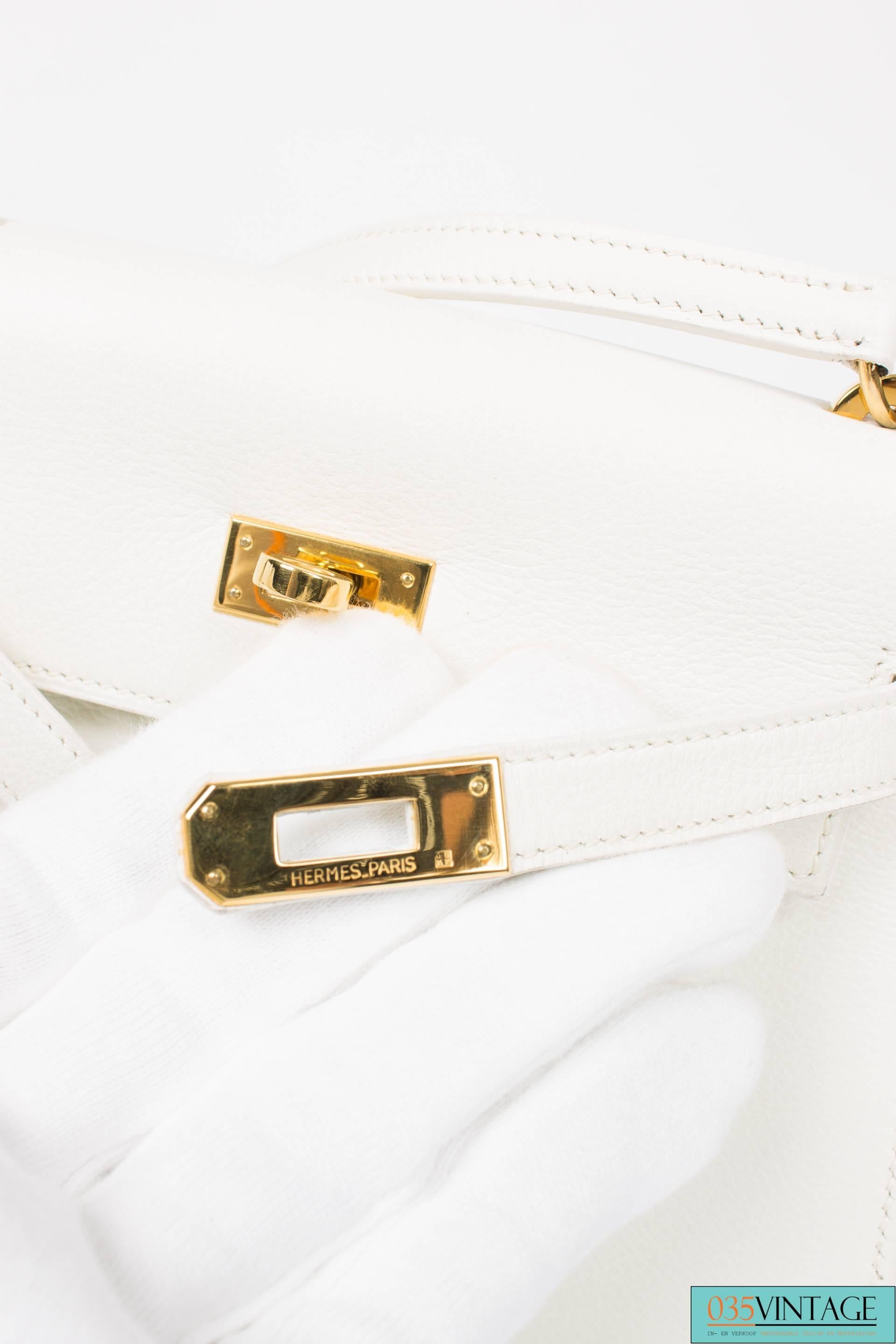 
We did not have this one before; the Hermès Mini Kelly Bag 20. A real baby Kelly!

The hardware is gold plated and the sturdy leather white. A traditional Kelly turnlock closure, only this time without the lock. The exterior is clean and