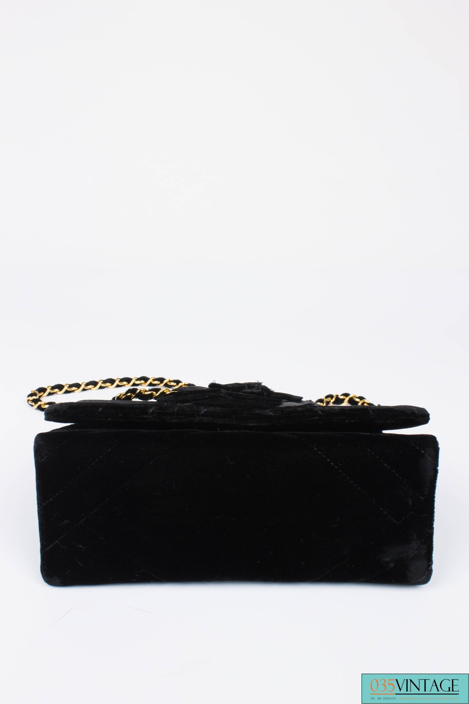 Vintage candy in black velvet; the Chanel Velvet Camellia Mini Flap Bag.

This bag is made between 1991 en 1994, but still in a very good condition. The velvet is tarry black and the golden chain shines right at you. The chain measures 115