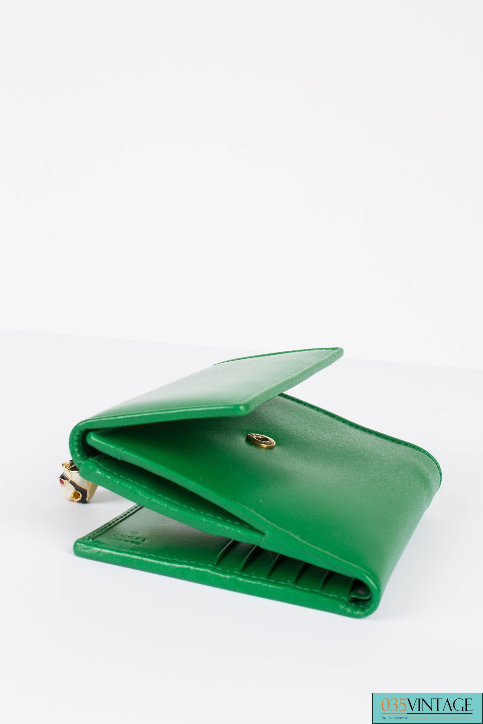 Exciting Gucci billfold wallet with a tiger's head for closure. Roooaaarrrr!

This wallet is from the Tigrette collection by Gucci and it's made of sturdy green leather. At the back a little pocket to store your coins, it closes with a push