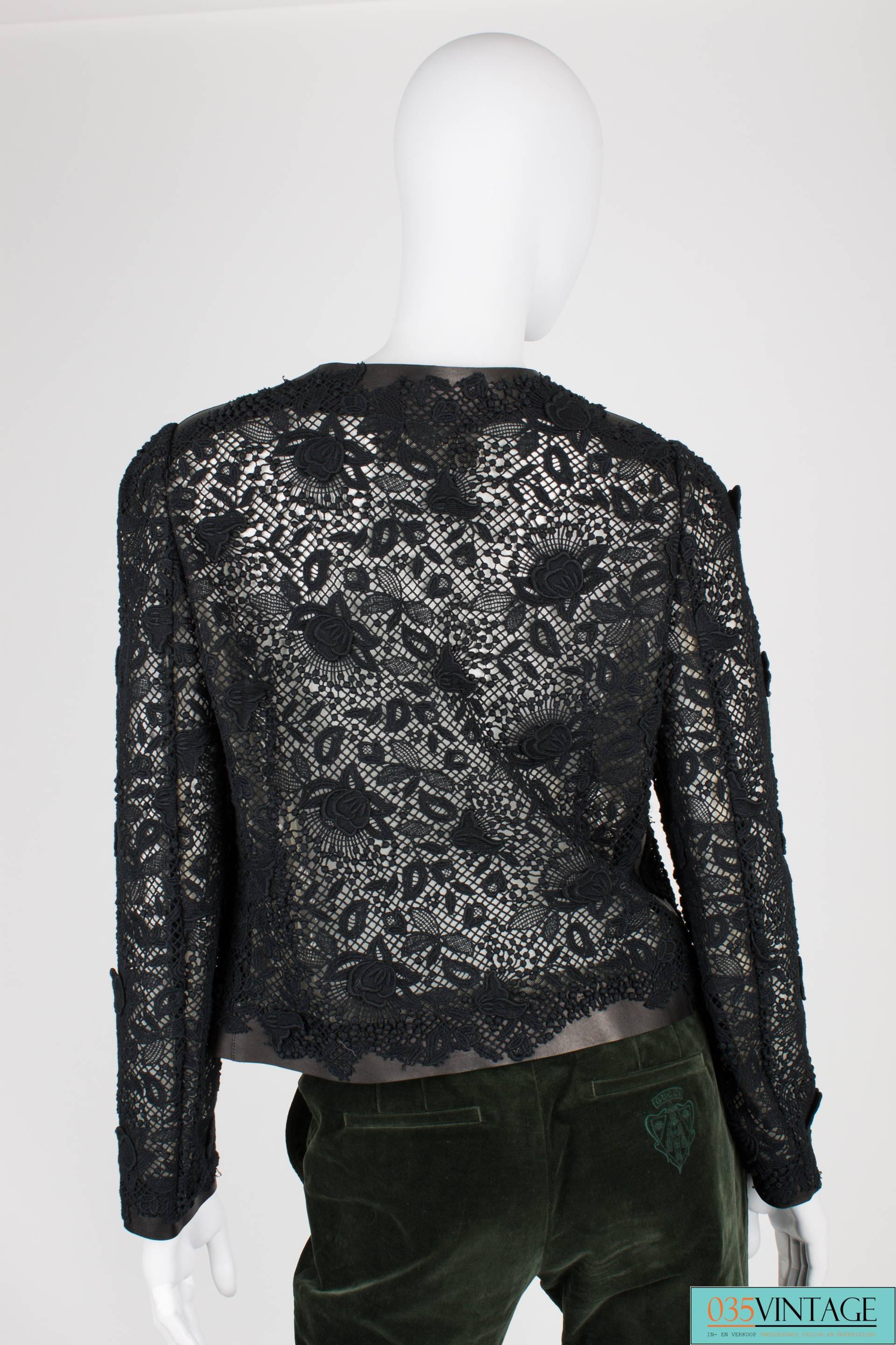 A beautiful black jacket by Valentino made of lace and leather. Very special!

The foundation of this jacket is made of leather, very noticable at the round neckline, shoulders, sleeves and hem. Front closure with three large leather bows and a