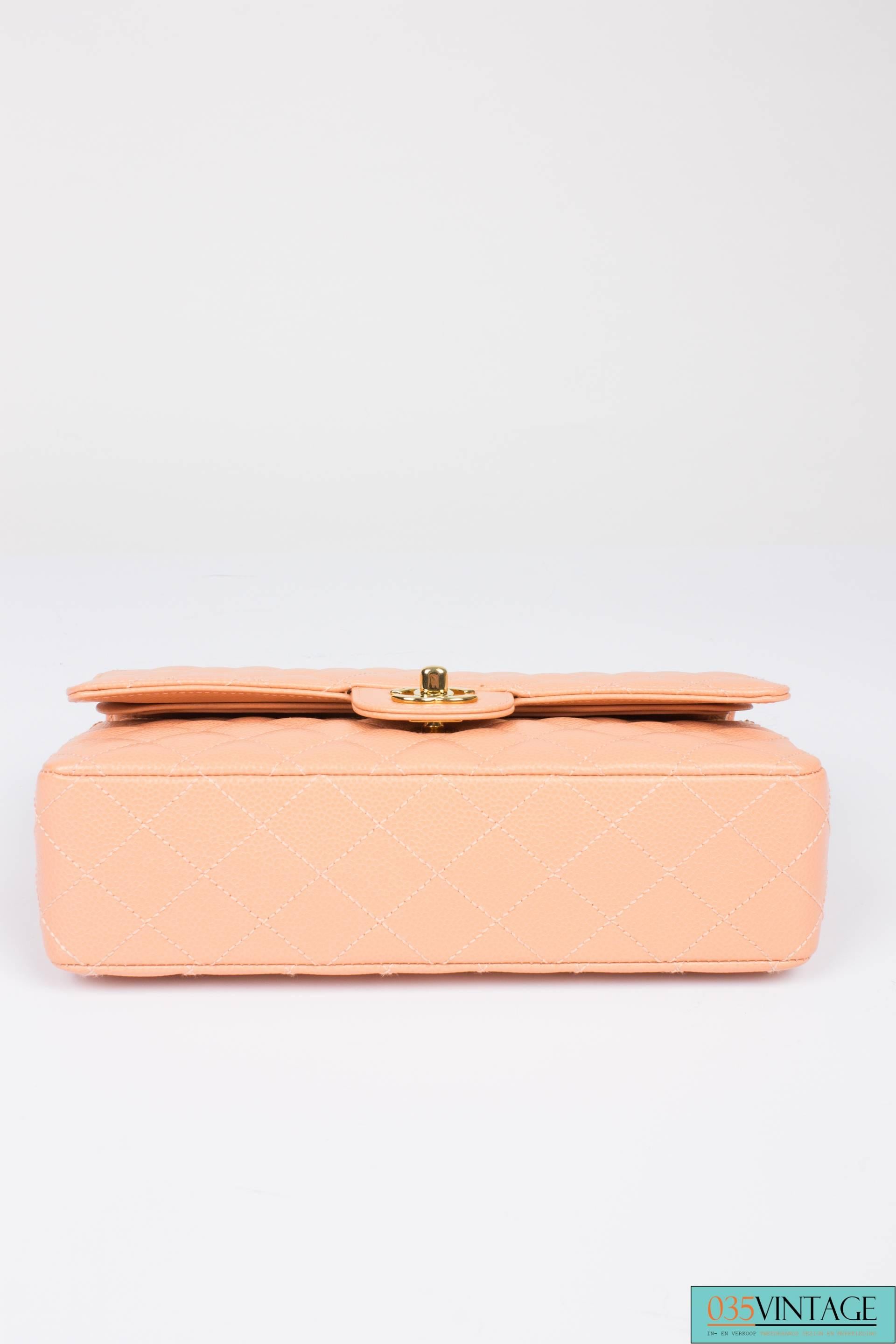 Classic bag by Chanel in very pale peach caviar leather, this piece is like new!

This 2.55 medium double flap bag is the middle size of this classic model and measures 26 centimeters in length and is 16 centimeters high. A golden chain which can