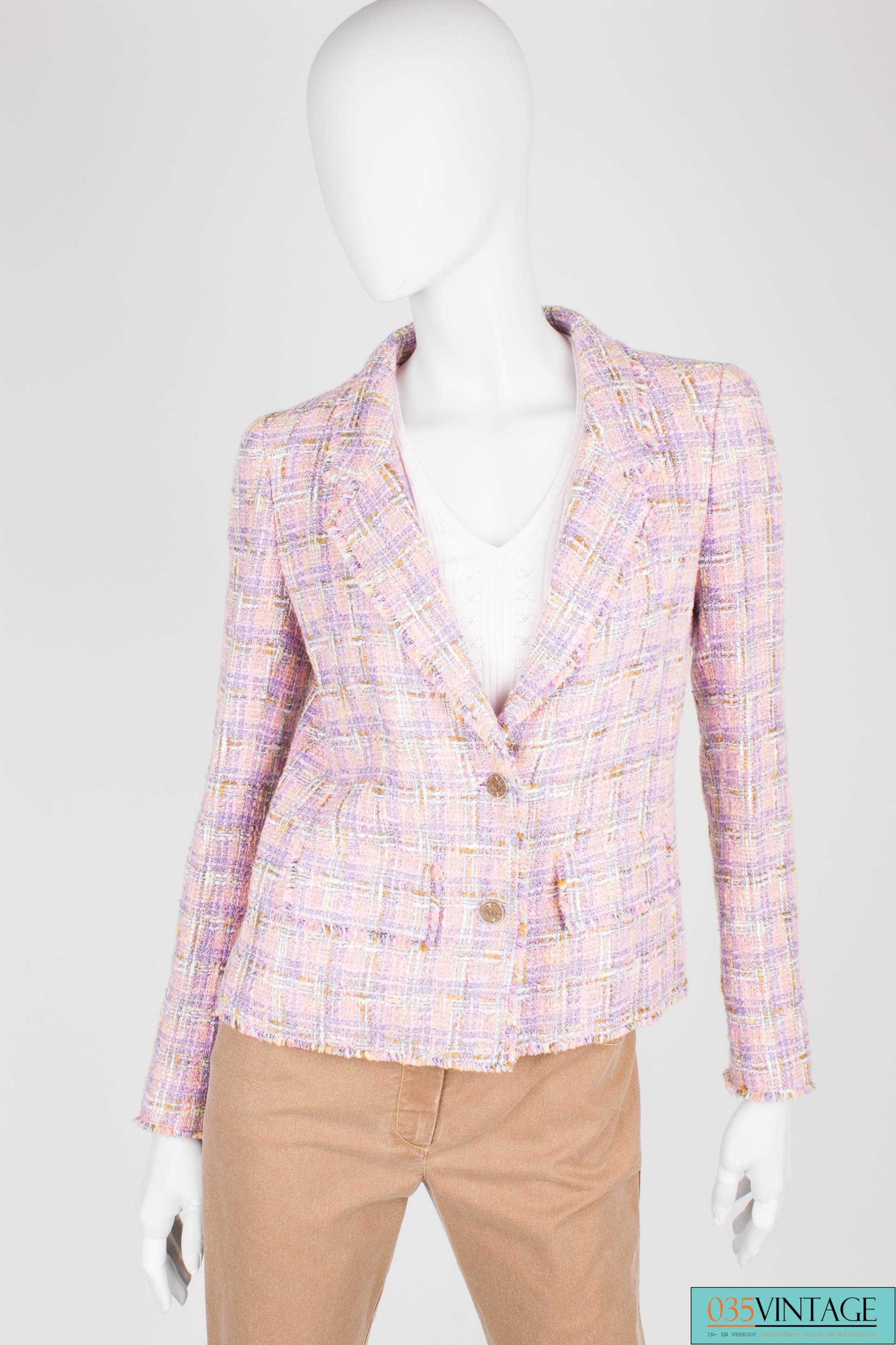 Three piece suit by Chanel; a jacket, pants and top.

The jacket is made of purple, pink, brown and white bouclé. Front closure with two metal buttons, three of these buttons at the end of the sleeves. A little smaller of course. Two flap