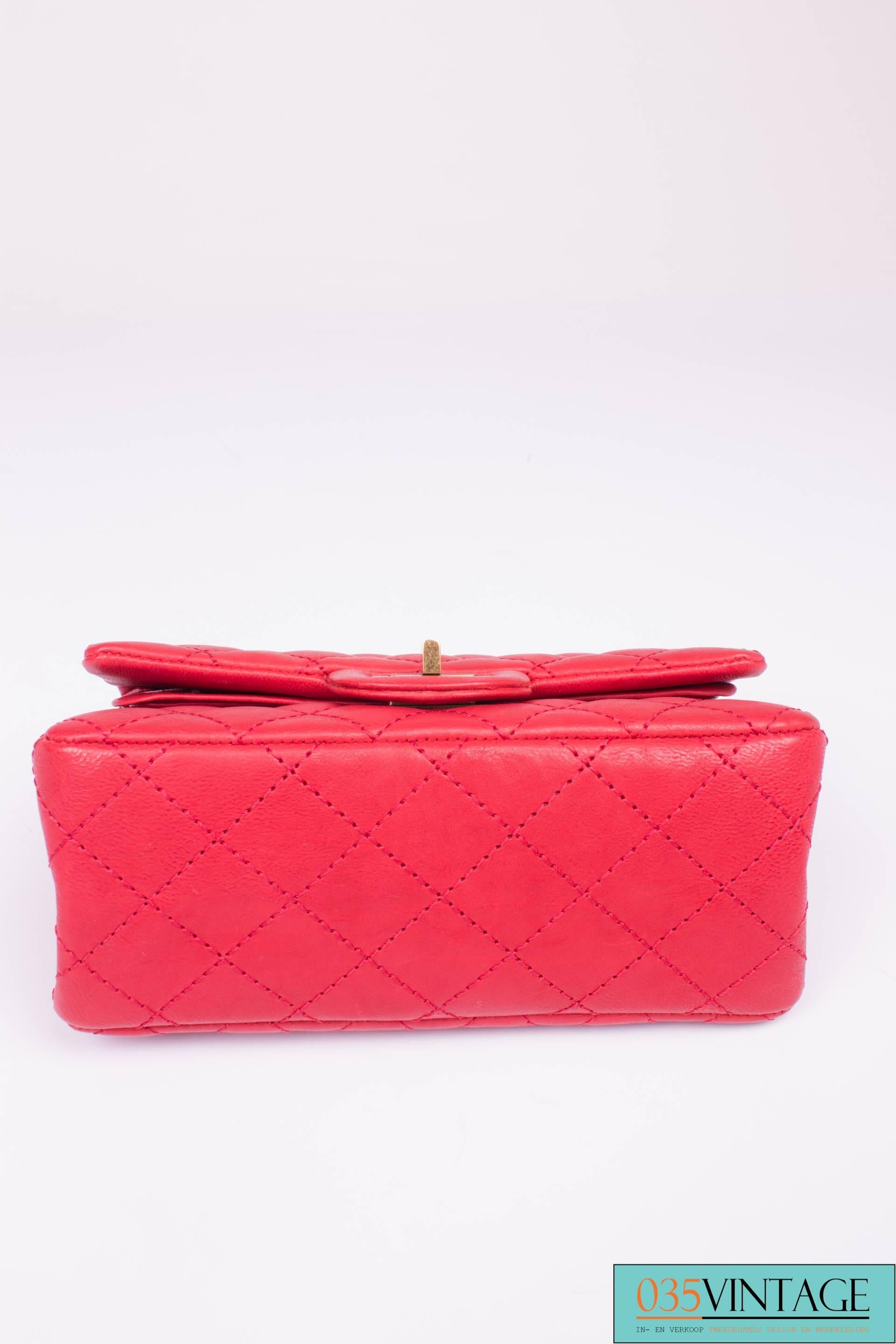 Classic bag by Chanel, in a 'mini' version, très chique! 

This matte red Chanel 2.55 mini double flap bag is one of the smaller sizes of this classic model and measures 20 centimeters in length, is13 centimeters high and 8 centimeters deep. A
