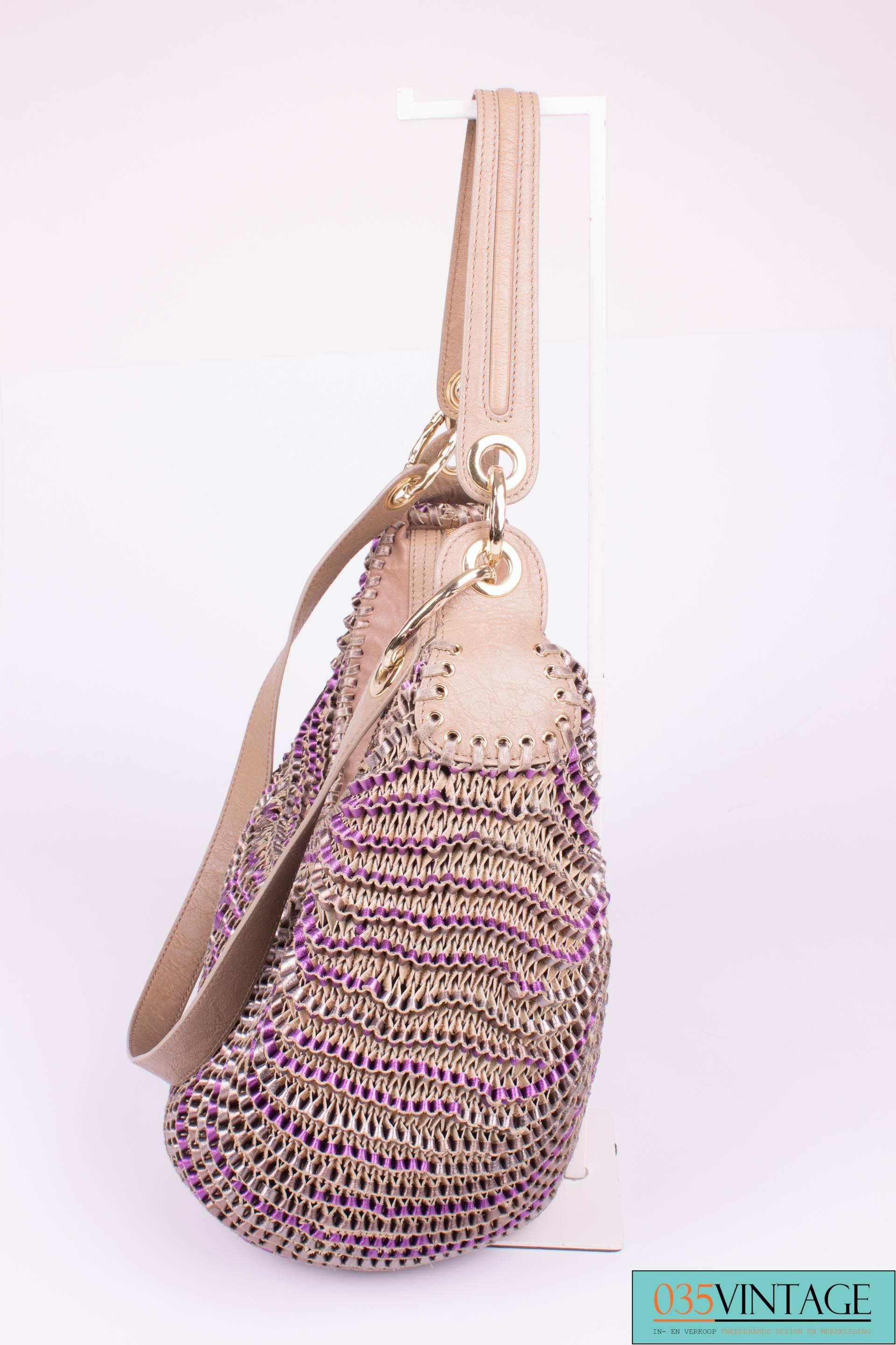 Beautiful bag by Diane von Furstenberg in woven leather, the name of this bag is Stepanie.

This bag closes with a golden zipper on top. A large golden dangle is attached to it. Two handles, a longer and a shorter one. 

The woven leather has two