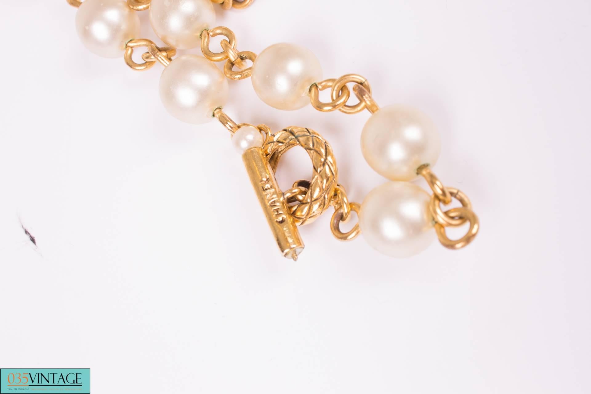 Straight from the 90's... Outstanding statement piece, a pearl necklace with a large golden charm by Chanel.

A real eyecatcher, the large faux pearls are connected with a golden chain and the charm measures as much as 10 x 6 centimeters.

This