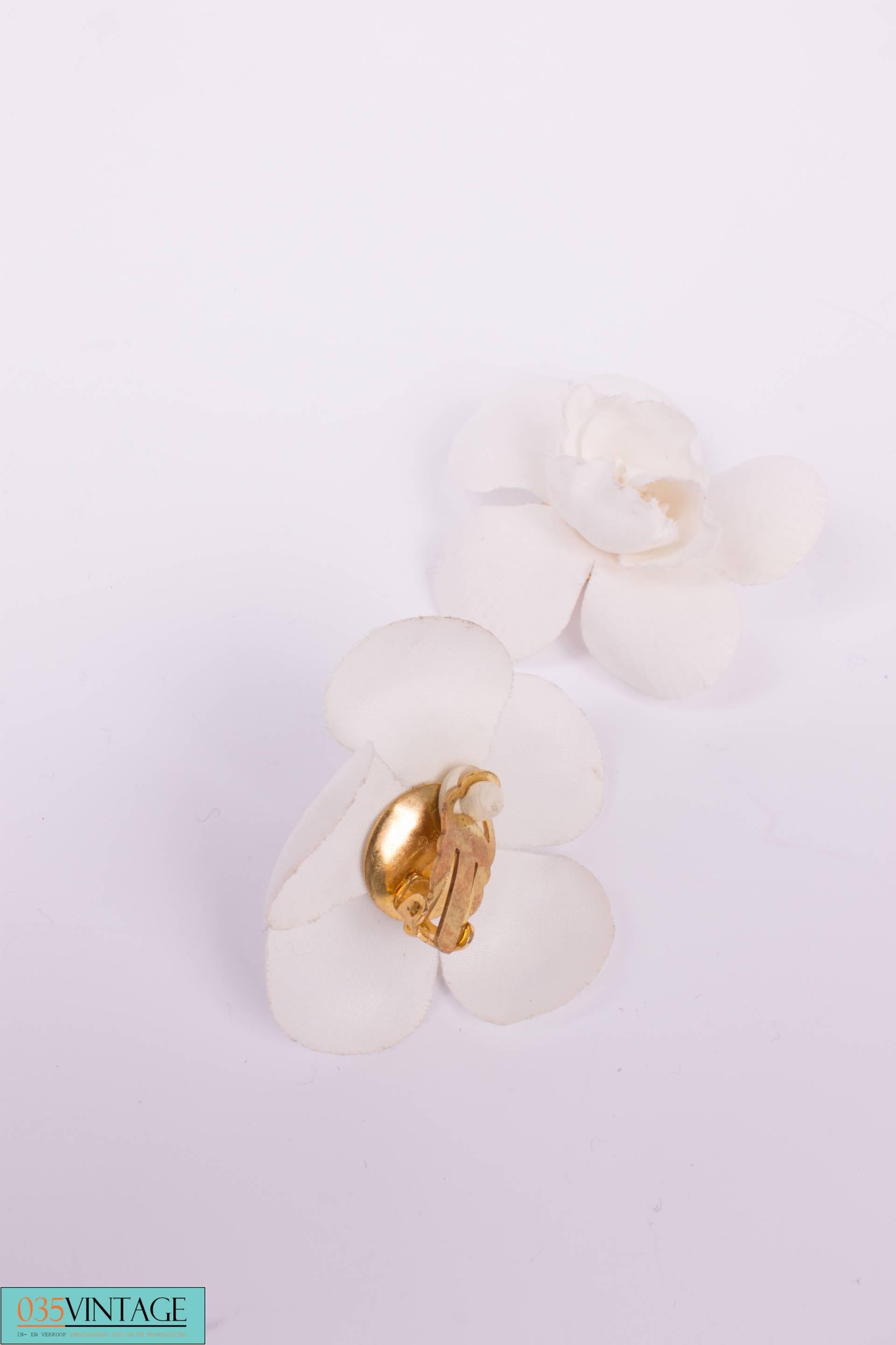 How sweet! Set of Camellia earrings by Chanel executed in white silk from the spring collection of 1988.

These earrings have a goldtone clip on the back, of course with the Chanel logo. At the front five large petals and four smaller ones in the