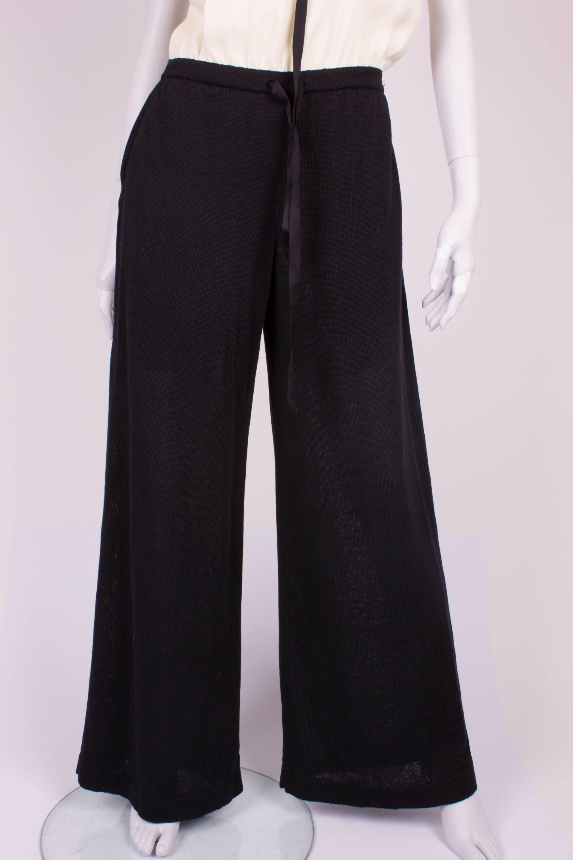 Stylish jump suit by Chanel in black and white.

The upper part is made of silk and fully lined. In the hem on top some elastic is added, the jump suit will not come down. A black bow on top and also one in the waist.

The supple pants are made of