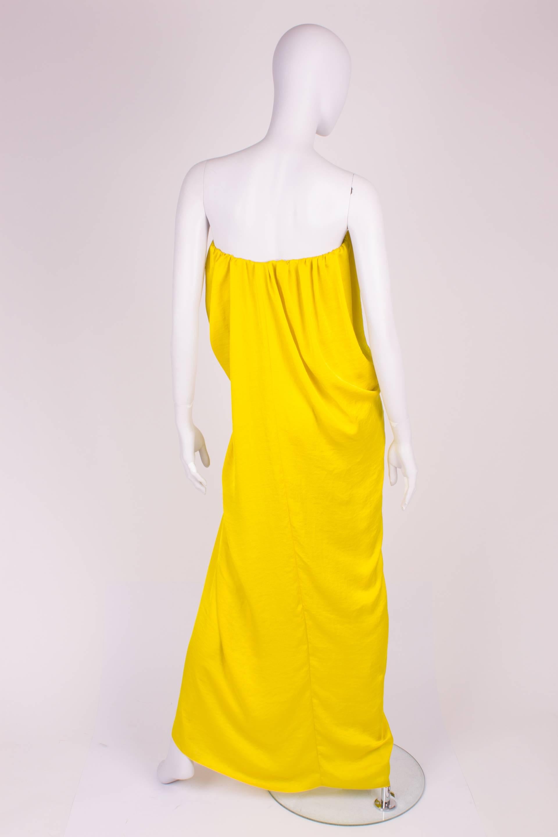 This canary yellow, strapless Lanvin evening dress will give you a special aura. He is easily combined with for example a summer scarf. He stays in place by the elastic corset at the chest. As a result, there's also beautiful folds in the dress. The