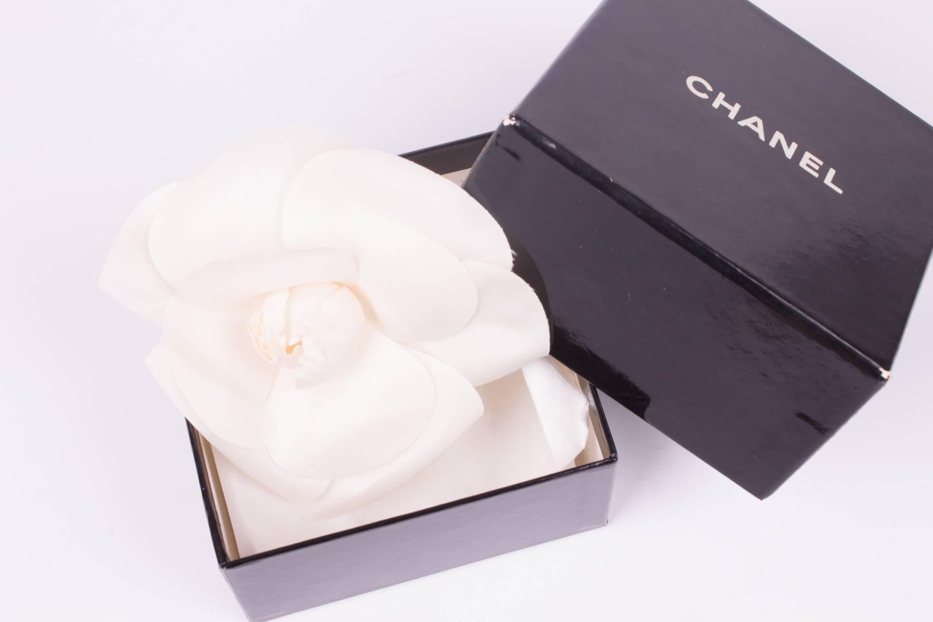 This one is fantastic! A silk camellia flower, known as the signature of Chanel, to be worn as a brooch!

It measures as much as 12 x 12 centimeters and is a real statement on your blouse or the lapels of your jacket. Fully made of white silk, 6