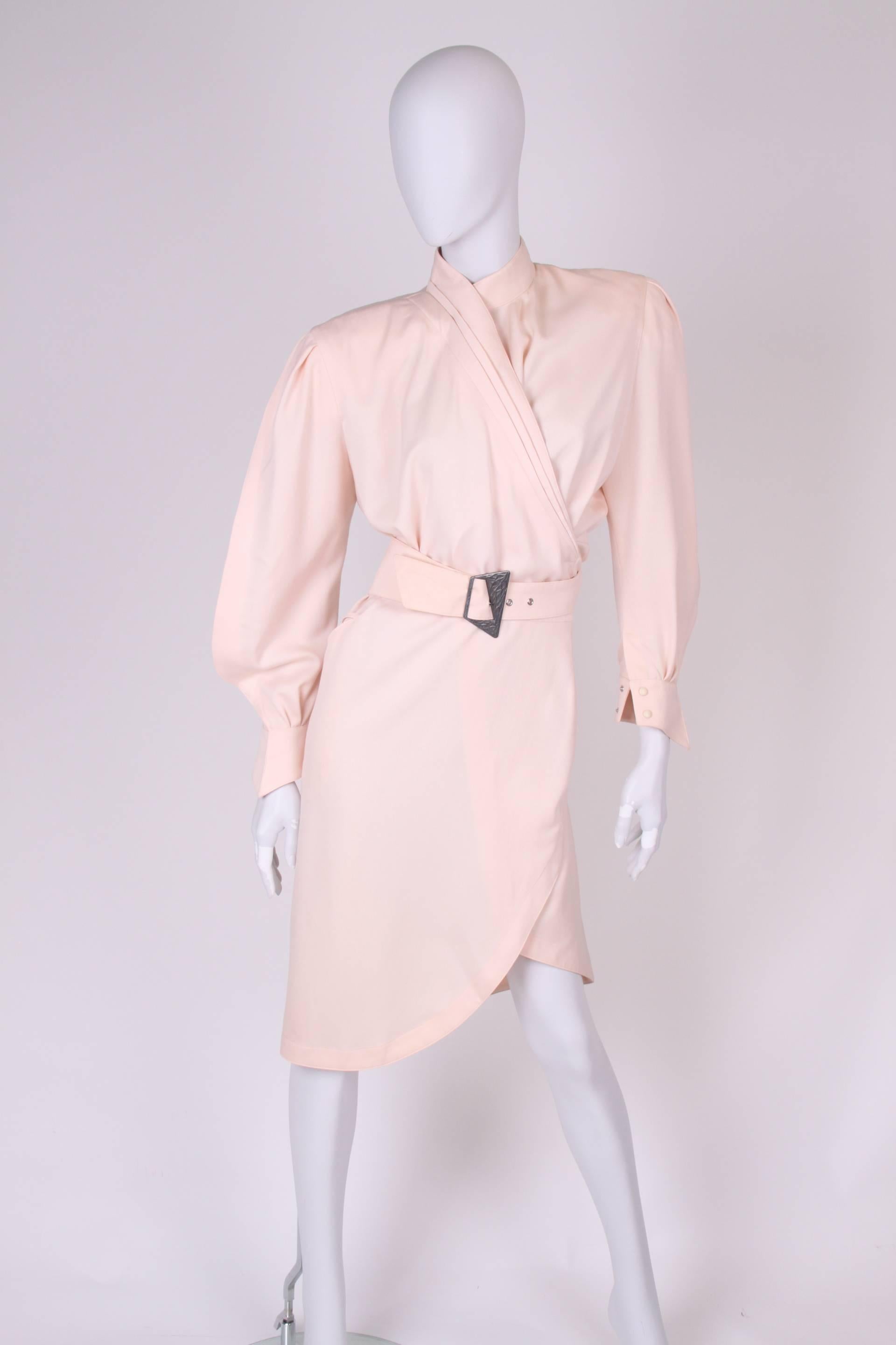 Vintage alert! Straight from the eighties: a salmon pink wrap dress by Thierry Mugler. We love it!

This high necked dress has more than knee length and has a matte silver buckle closure. Two welt pockets on the hips. No lining, large padding in the