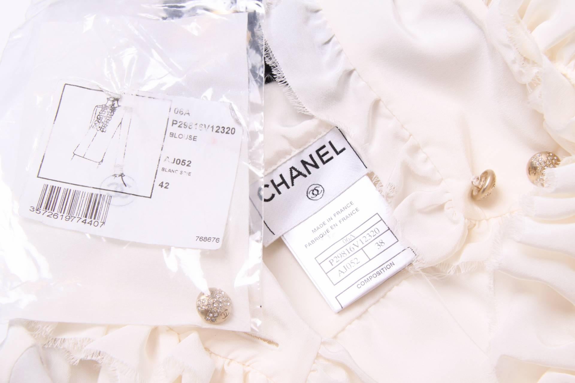 Oh heavenly beauty! Chanel blouse with ruffles... If only!

Made of 100% ivory coloured silk, long sleeves and a mandarin collar. Front closure with six matte gold-tone buttons covered wiht little crystals and a CC logo.

The front panel is slightly