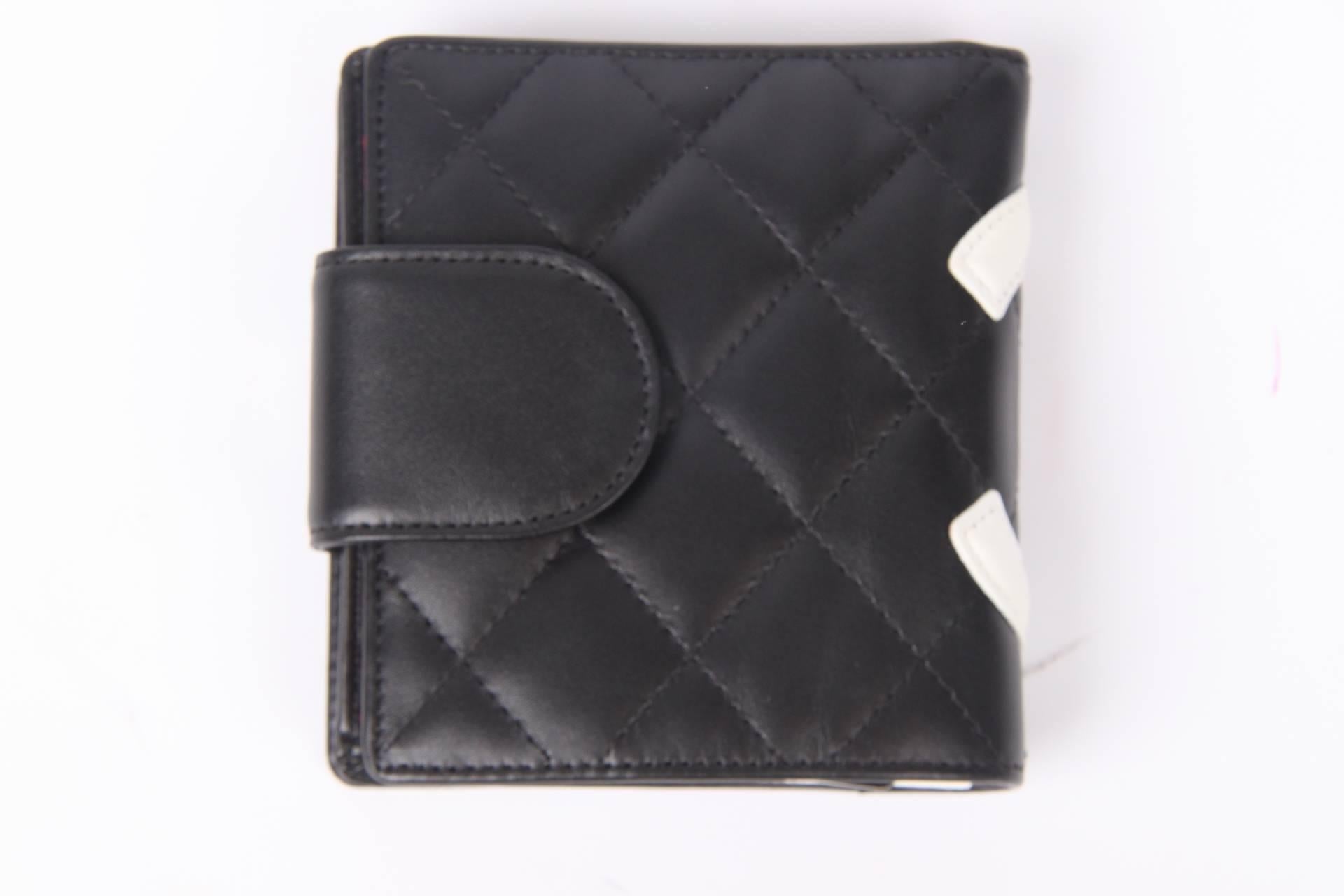 This one is brand new and fantastic! It is the Chanel Quilted Ligne Cambon Billfold Compact Wallet in black and white leather.

The black leather is fully quilted and has a large stitched CC logo in white. On the inside lining in bright pink covered