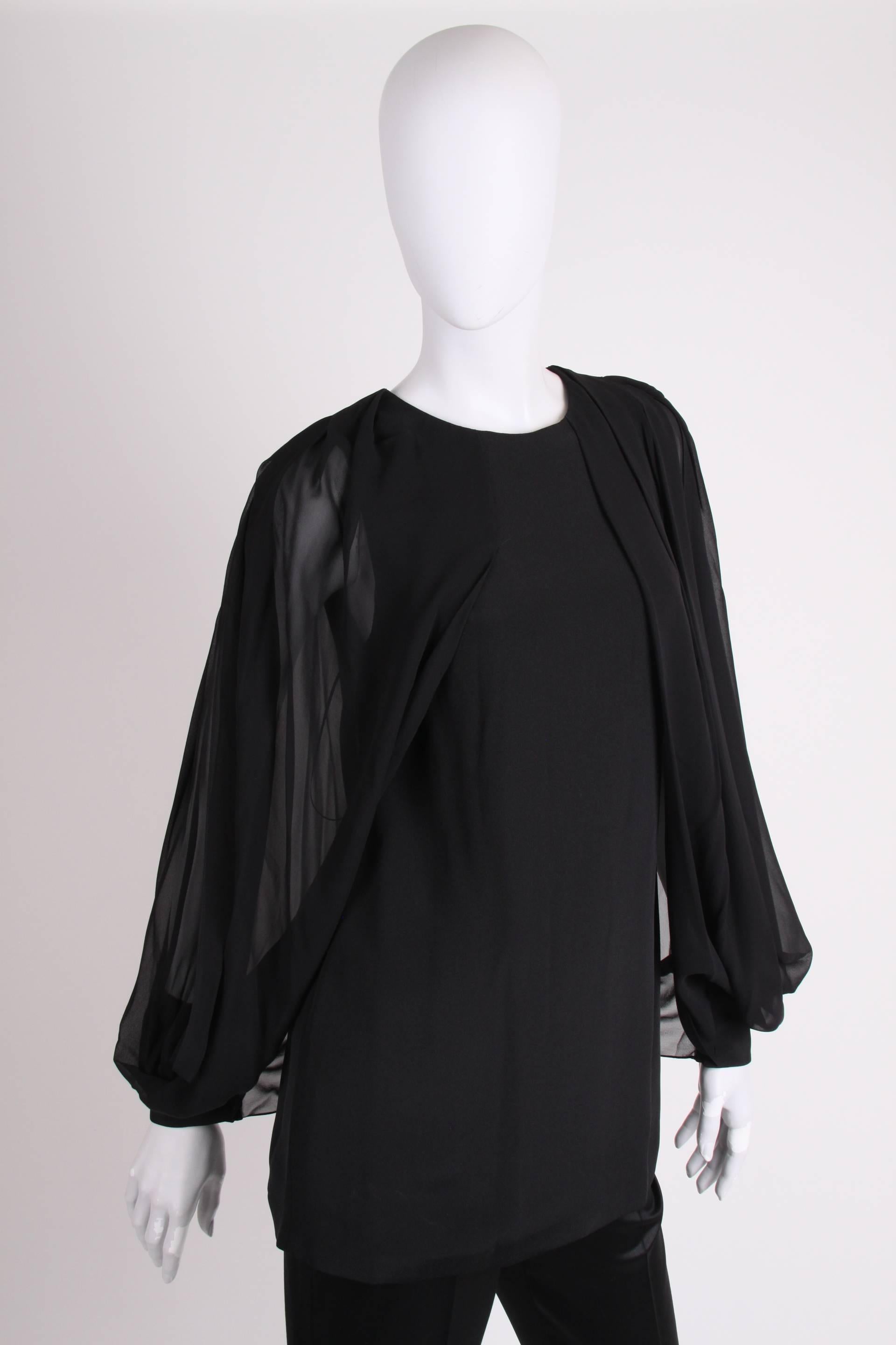 Gucci at its best: a black silk blouse with open sleeves. Super chic!

This blouse has more than hip length, is lined on the inside and has back closure with one single button in the neck. This reveals a small part of the back.

The sleeves are