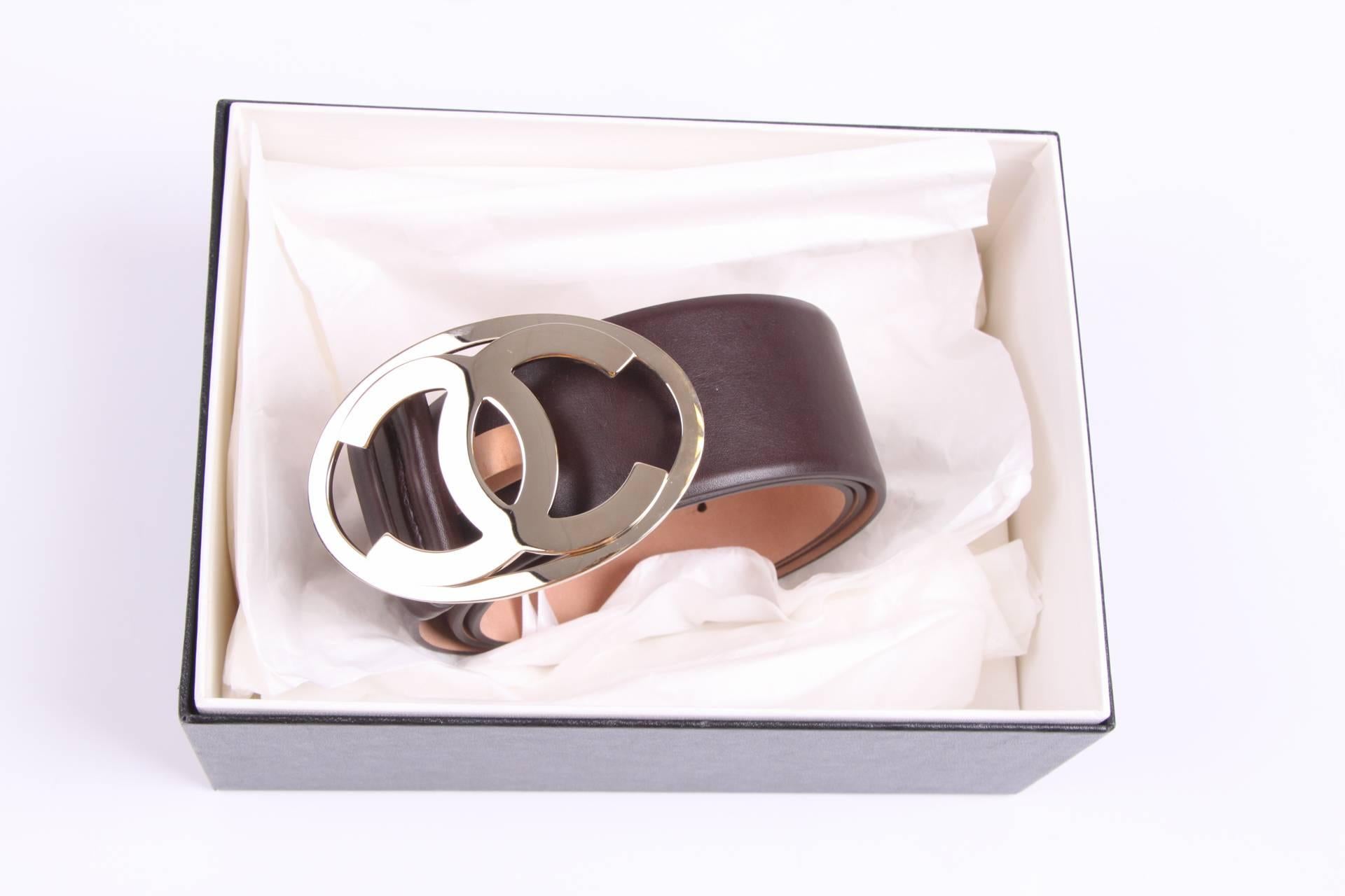 Stylish dark brown belt by Chanel with a silver-tone CC buckle.

This belt is 5 centimeters wide and is fully made of brown calfskin leather, the inside of the belt is nude coloured. The large shiny buckle measures as much as 10 x 6,5 centimters. A