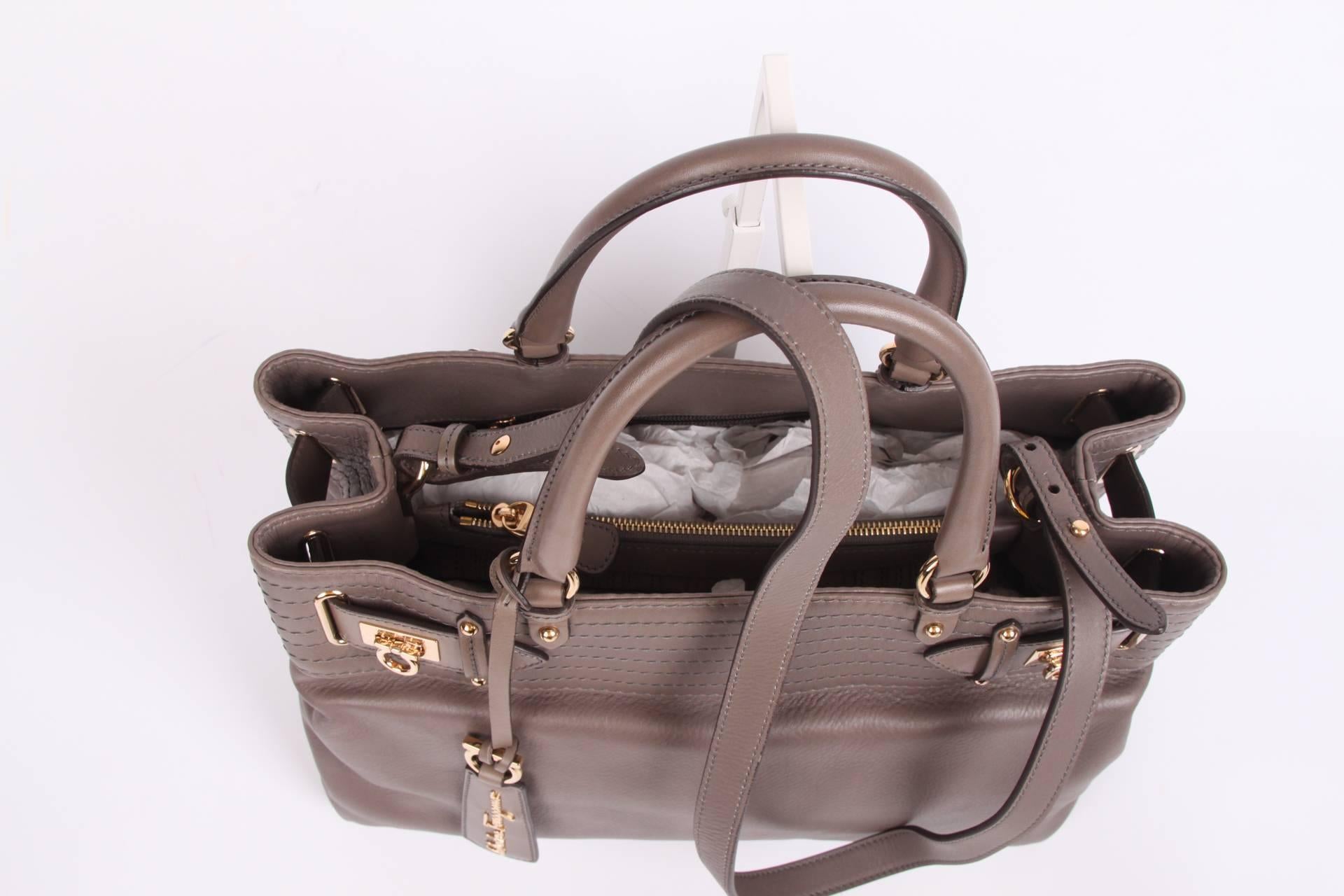 Super stylish bag by Salvatore Ferragamo, due to its rather large size also very suitable for the office. Very pretty!

Made of calfskin leather in a wonderful shade of taupe. Two handles on top and also an adjustable and detachable shoulder strap.